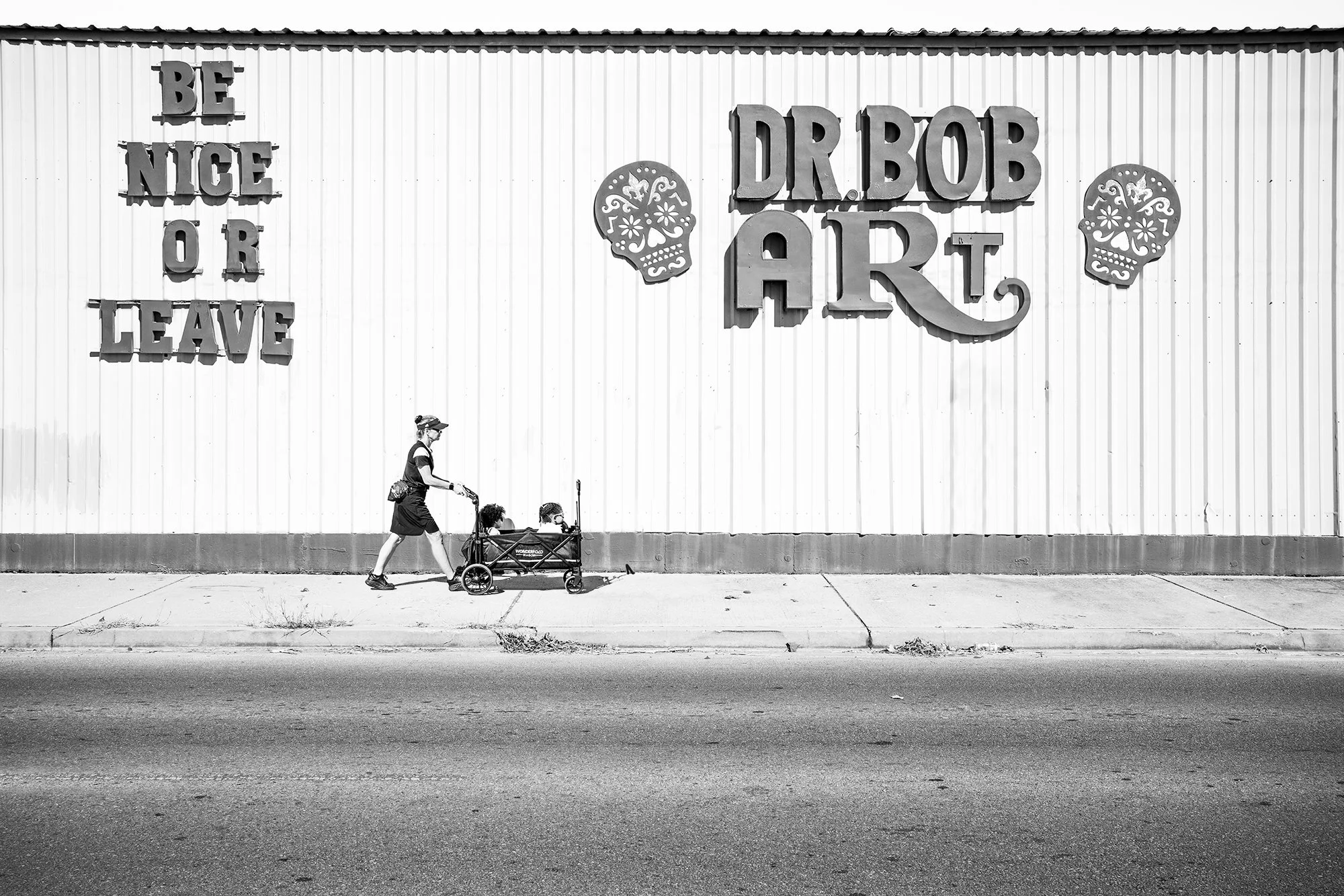 Lady with kids walking in front of Dr Bob Art store in Marigny, New Orleans, Louisiana, USA