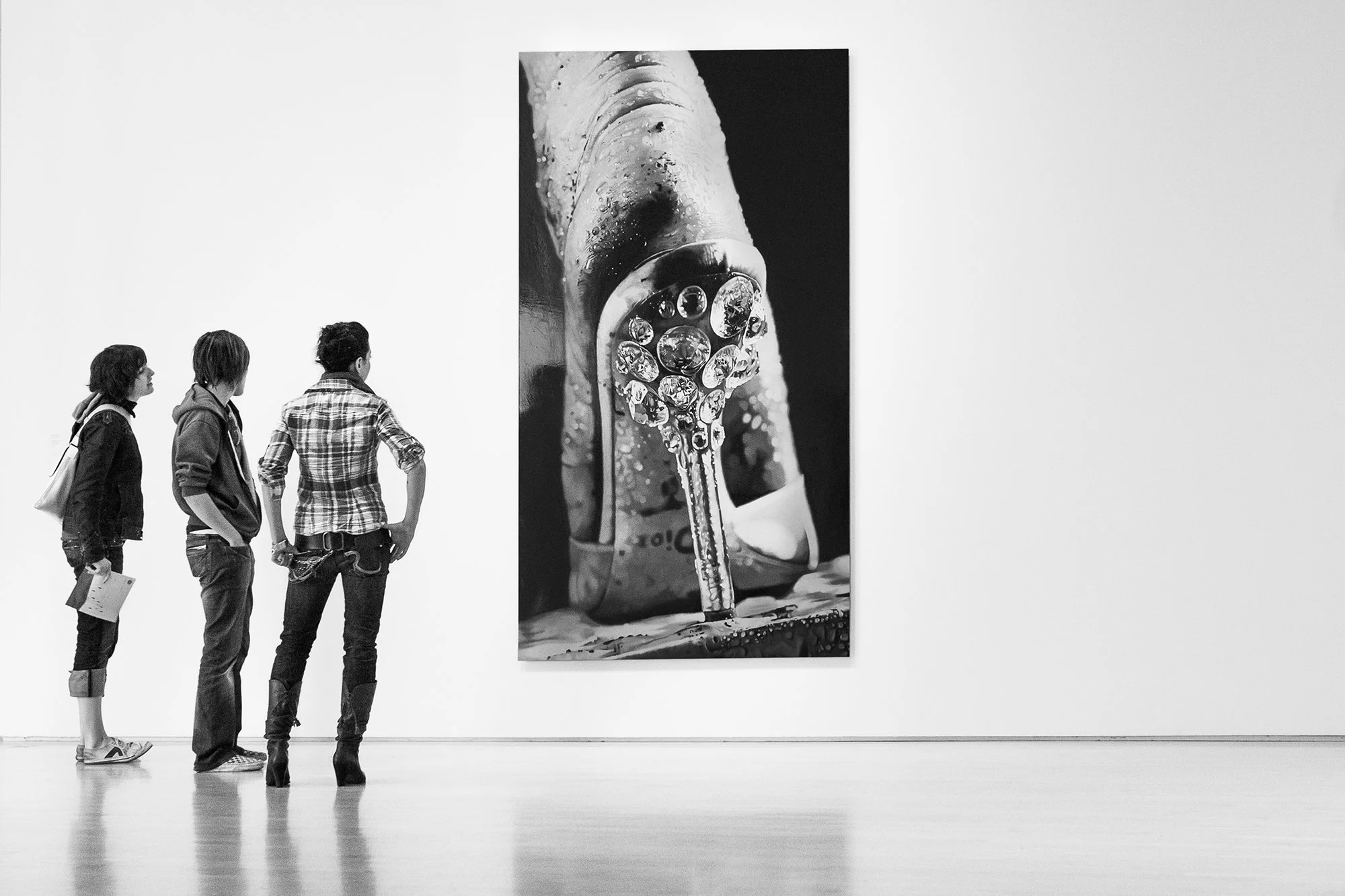 Three teenagers looking at a Dior photo at San Francisco MOMA, San Francisco, California, USA