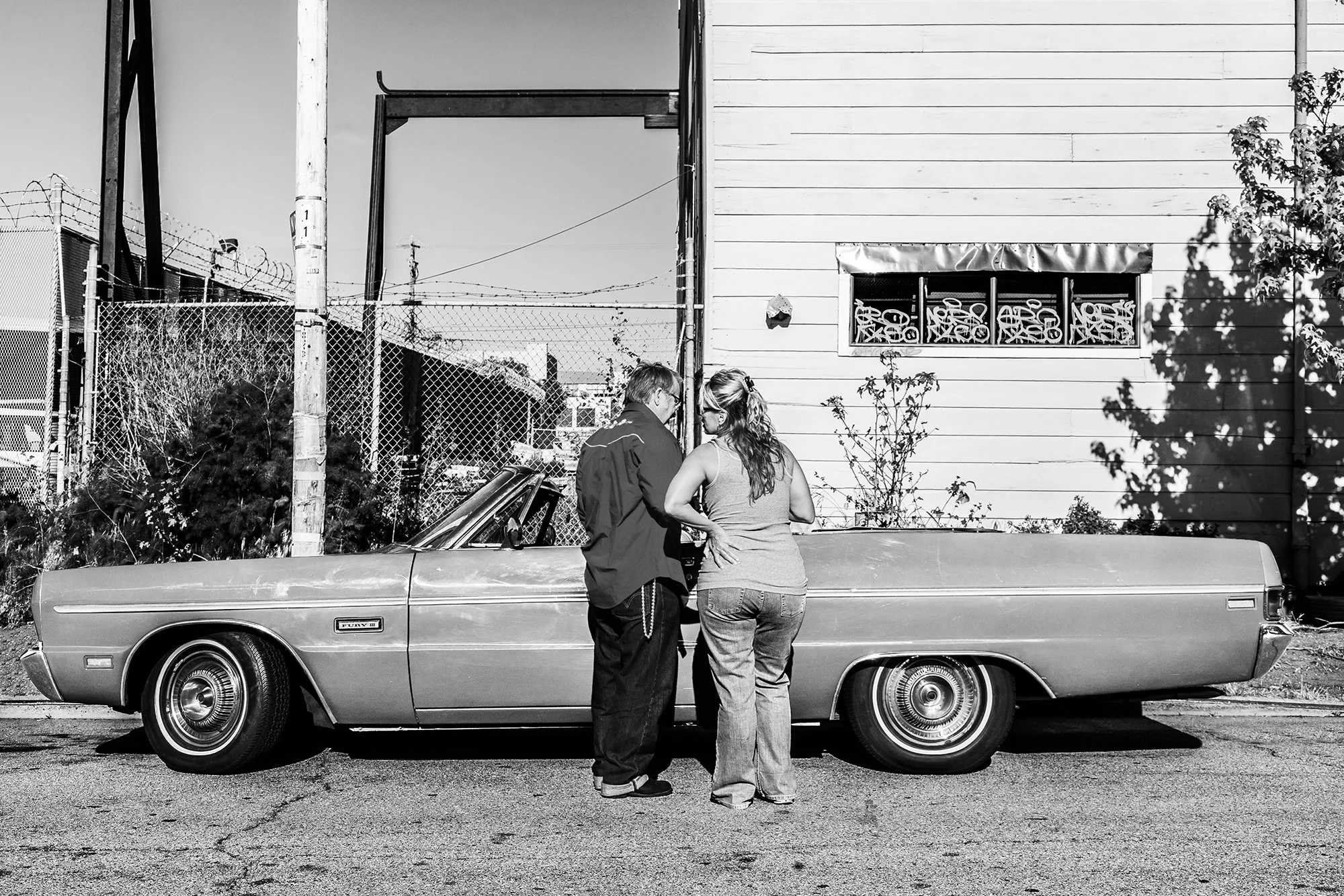 Man and Woman arguing in front of Plymouth Fury, Bay View, San Francisco, California, USA