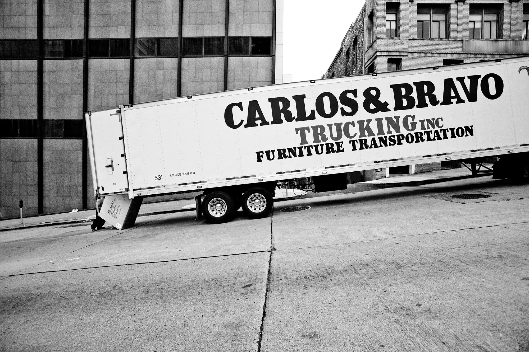 Trucker loading large box in truck, Downtown, San Francisco, California, USA