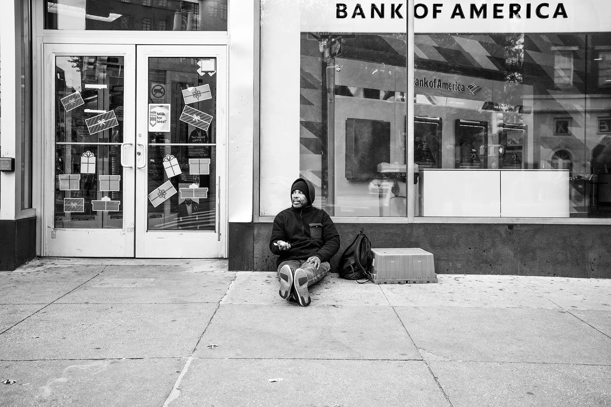 Beggar sitting on the street in front of Bank of America, Manhattan, New York City, USA