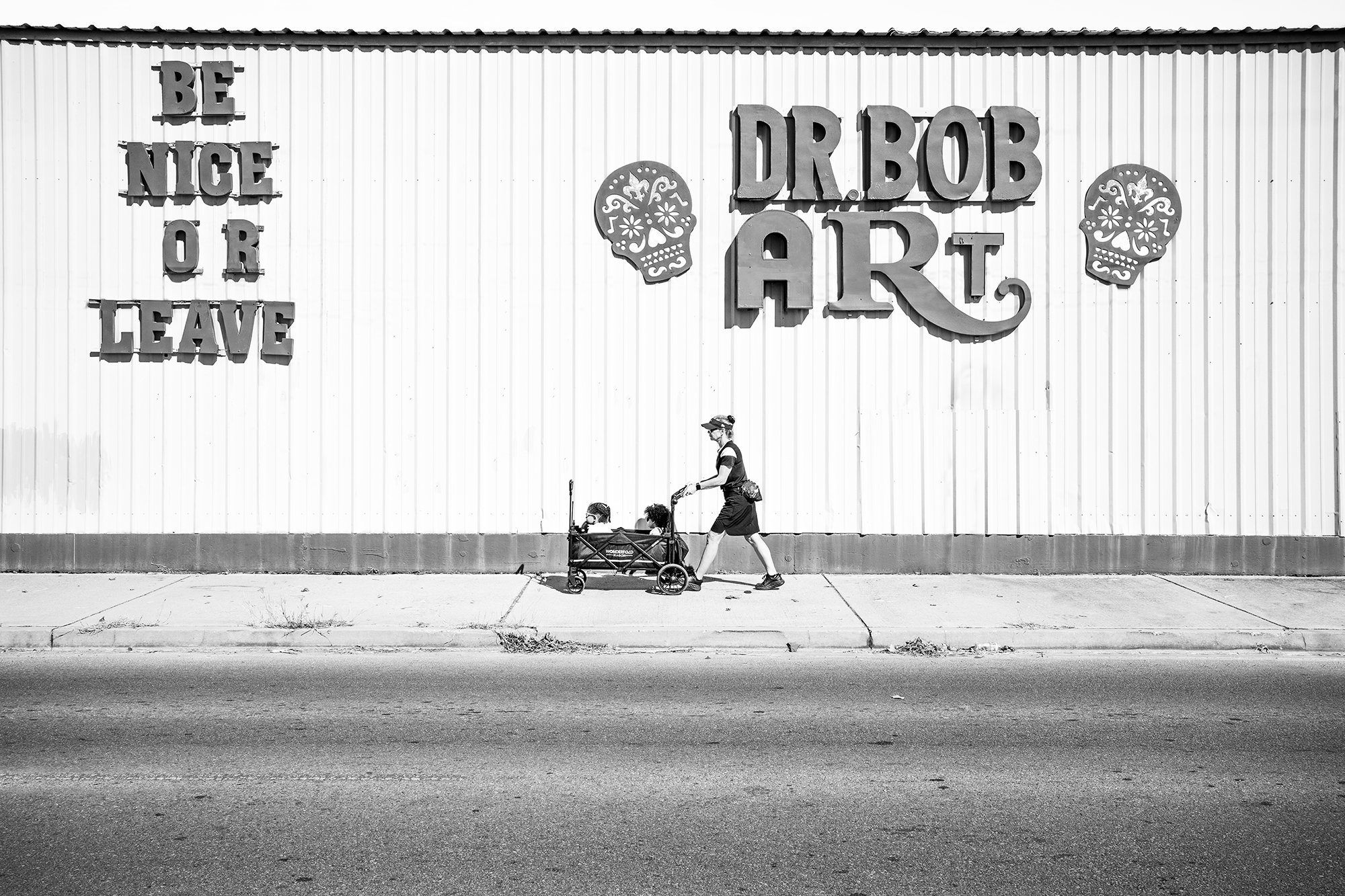 Lady with kids walking in front of Dr Bob Art store in Marigny, New Orleans, Louisiana, USA