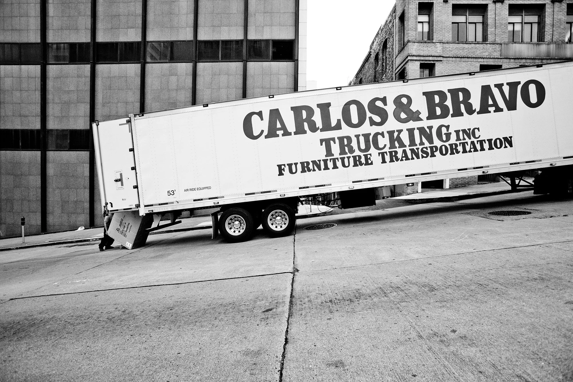 Trucker loading large box in truck, Downtown, San Francisco, California, USA