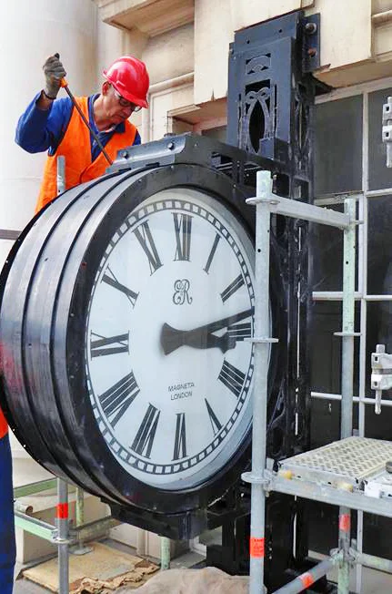 Worker removing old clock from outside the CPO building