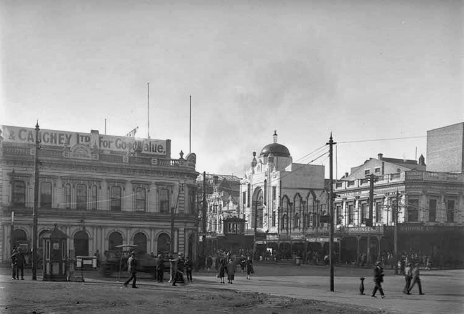 1927: Note the tramlines and the tram control "cabin" (in the centre) at this intersection of Queen and Wellesley Streets. Smith and Caughey's is left) and premises on the east side of Queen Street including Regent Theatre (centre), Somervell's Tea and Luncheon Rooms, Melba Fur Company, Cruickshank, Miller and Company, Howie's Music Shop and George Browne Limited (Photo: Sir George Grey Special Collections, Auckland Libraries, 4-7643)