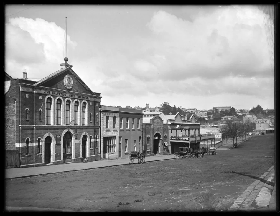 1907: Looking south east along Albert Street from the vicinity of Wellesley Street West, showing premises of the Salvation Army Barracks, H M Keesing, plumber, Pullar Armitage and Company, stables, Royal Albert Hall and the City Fresh Water Baths (Photo: Sir George Grey Special Collections, Auckland Libraries, 1-W887)