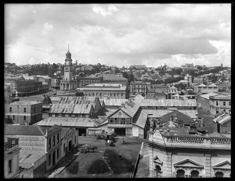 1917: Looking south from Archibald Clark's premises in Wellesley Street West over Market Square towards the Baptist Tabernacle and Karangahape Road, showing the City Markets (centre), Bledisloe Street (foreground), Ethel Buildings (right), premises of D Reid, furniture and produce mart, R Arthur and Company, auctioneers, E Turner and Sons, bulk store, Cook Street (left to right middle distance), O'Leary Brothers and Downs, seed merchants, Market Hotel (centre), Queen Street and Town Hall (left), Greys Avenue, with Myers Park and Kindergarten (distance) (Photo: Sir George Grey Special Collections, Auckland Libraries, 1-W1609)