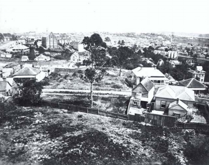   1870s: Looking west north west from Partington's Windmill, showing part of Karangahape Road (extreme left, distance), the Naval Hotel behind (left), Pitt Street Methodist Church (left distance), Liverpool Street (foreground), Queen Street, (centre 