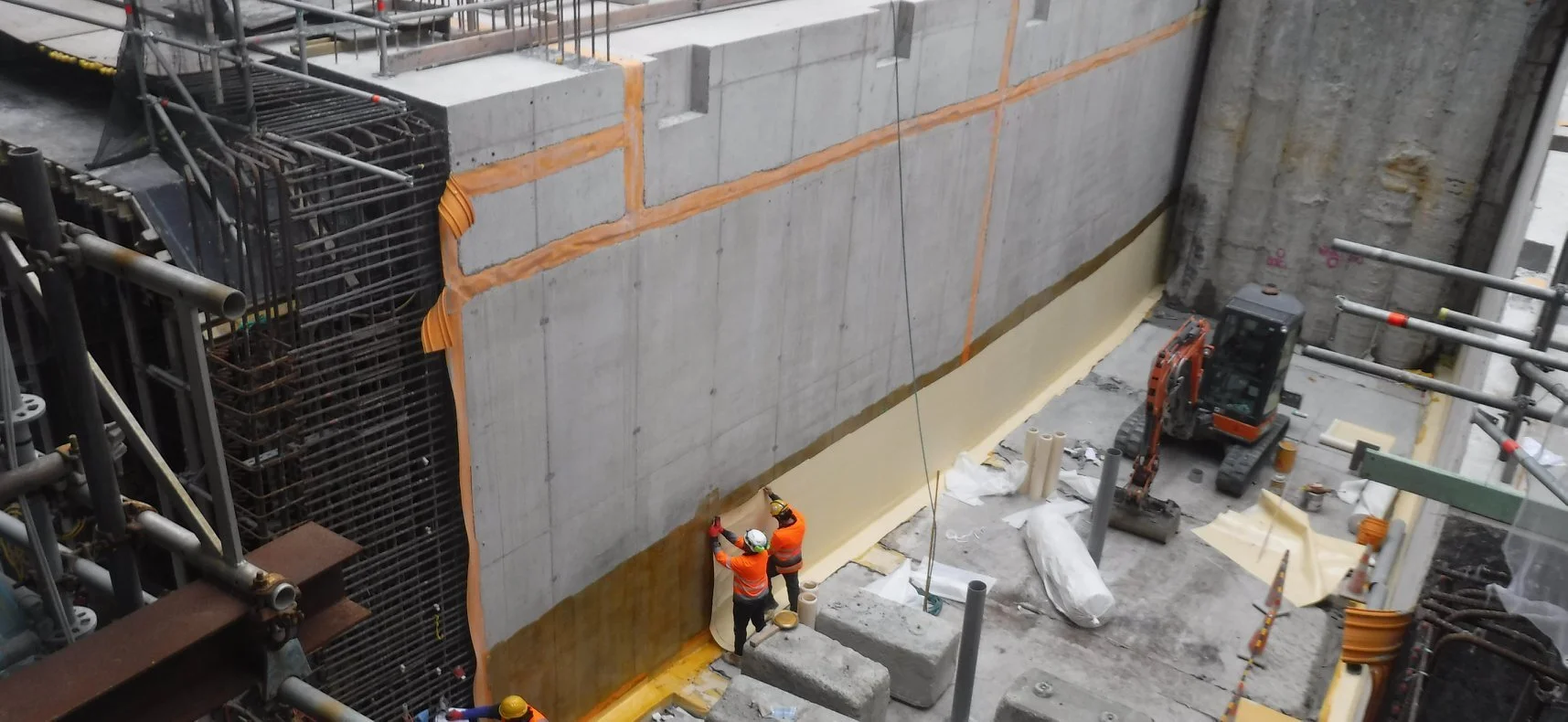 Workers apply waterproof membrane to one of the tunnel walls built in front of the Chief Post Office in lower Queen Street
