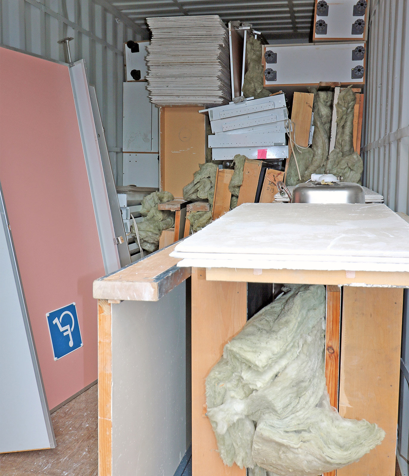   The containers were stacked full of desks, tables, doors, toilets, carpet tiles and cupboards  