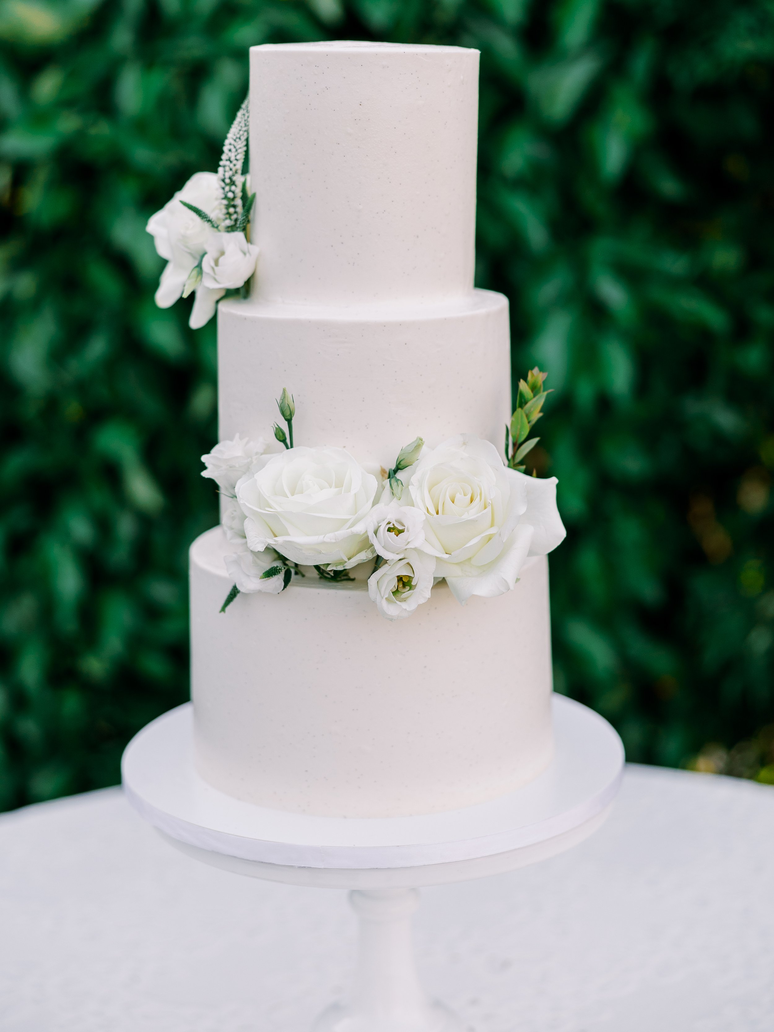 simple white buttercream wedding cake white flowers