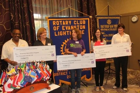 "Evanston Lighthouse Rotary Club presents $10,000 checks to the 2017 Taste of Evanston principal beneficiaries: Evanston We Program, No Boundaries/Search, Inc., and Evanston Rebuilding Warehouse, to support their outstanding and vital work-readiness programs. Photo Credit: John Searles. Nancy Baker, Executive Director of the Evanston WE Program Hecky Powell, Founder of the Evanston WE Program Lou Dickson, Executive Director of Evanston Rebuilding Warehouse, and Audrey Landale, Development Manager at Search, Inc