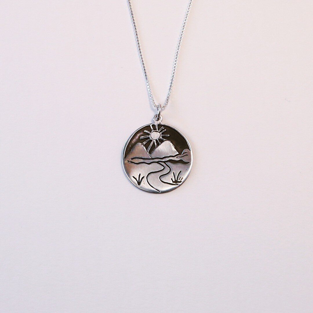 Road&ndash;Mountain&ndash;Sun
One of our more popular pendants. An elegant statement, &ldquo;the road that takes you away can always bring you home.&rdquo;
Visit our online shop at www.villagesilversmith.com to see more...