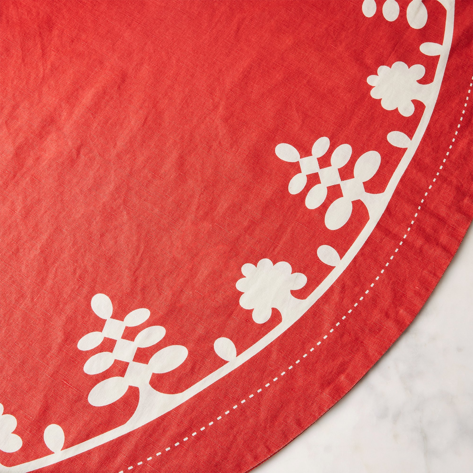 1012-1011_food52_mergentime-garland-tree-skirt_red-w-white_detail_silo_1x1_ty-mecham.jpg