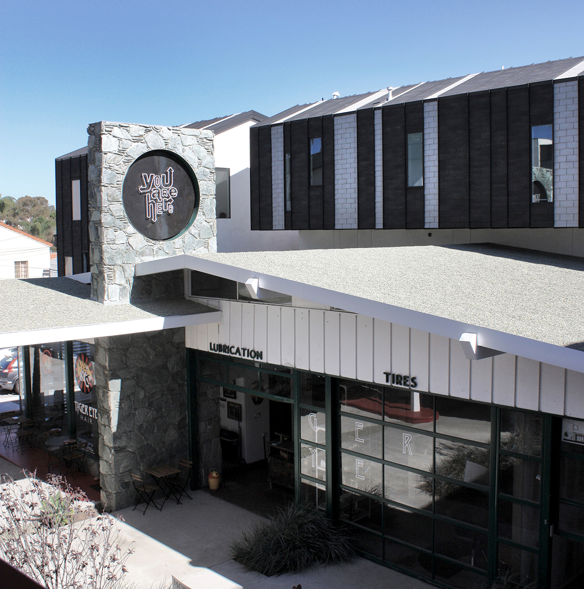 View of the rooftop sign. The existing gas station and stone sign structure remained as-is, and the rest of the mixed-use building was built around it. Architecture by Foundation for Form . You Are Here neon sign fabrication and photography by Tecture .