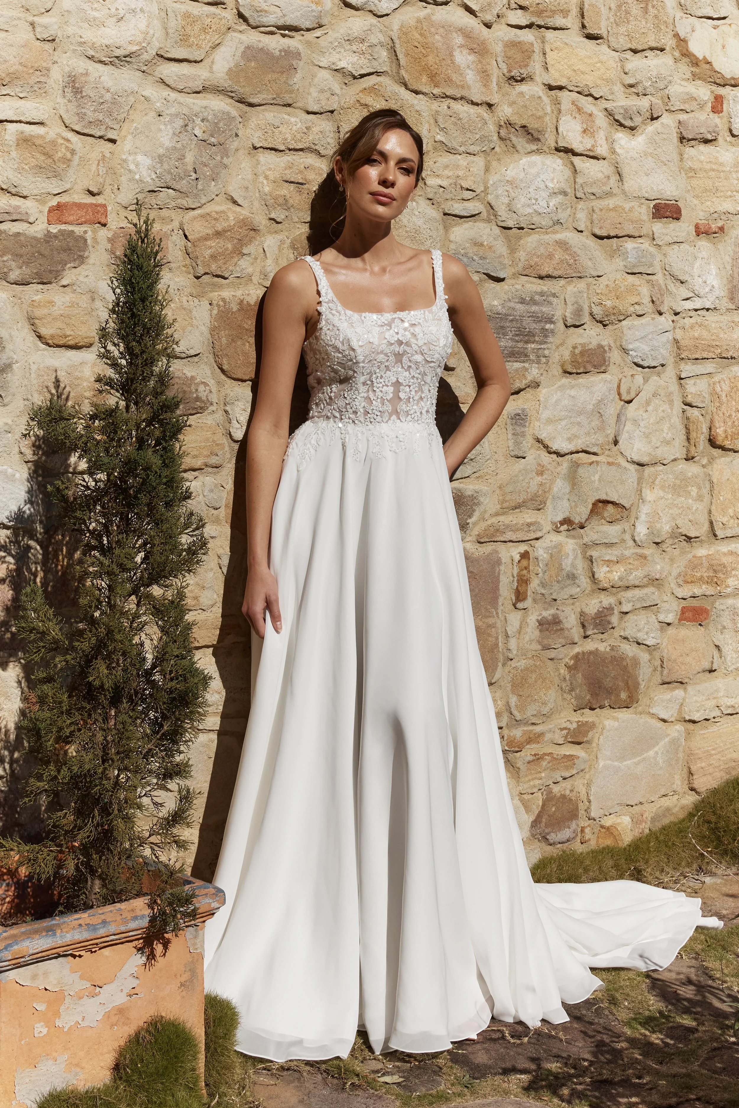 Zinnia front showing  A-line wedding dress in soft georgette with square neckline, lace appliqué bodice and flowing chapel train
