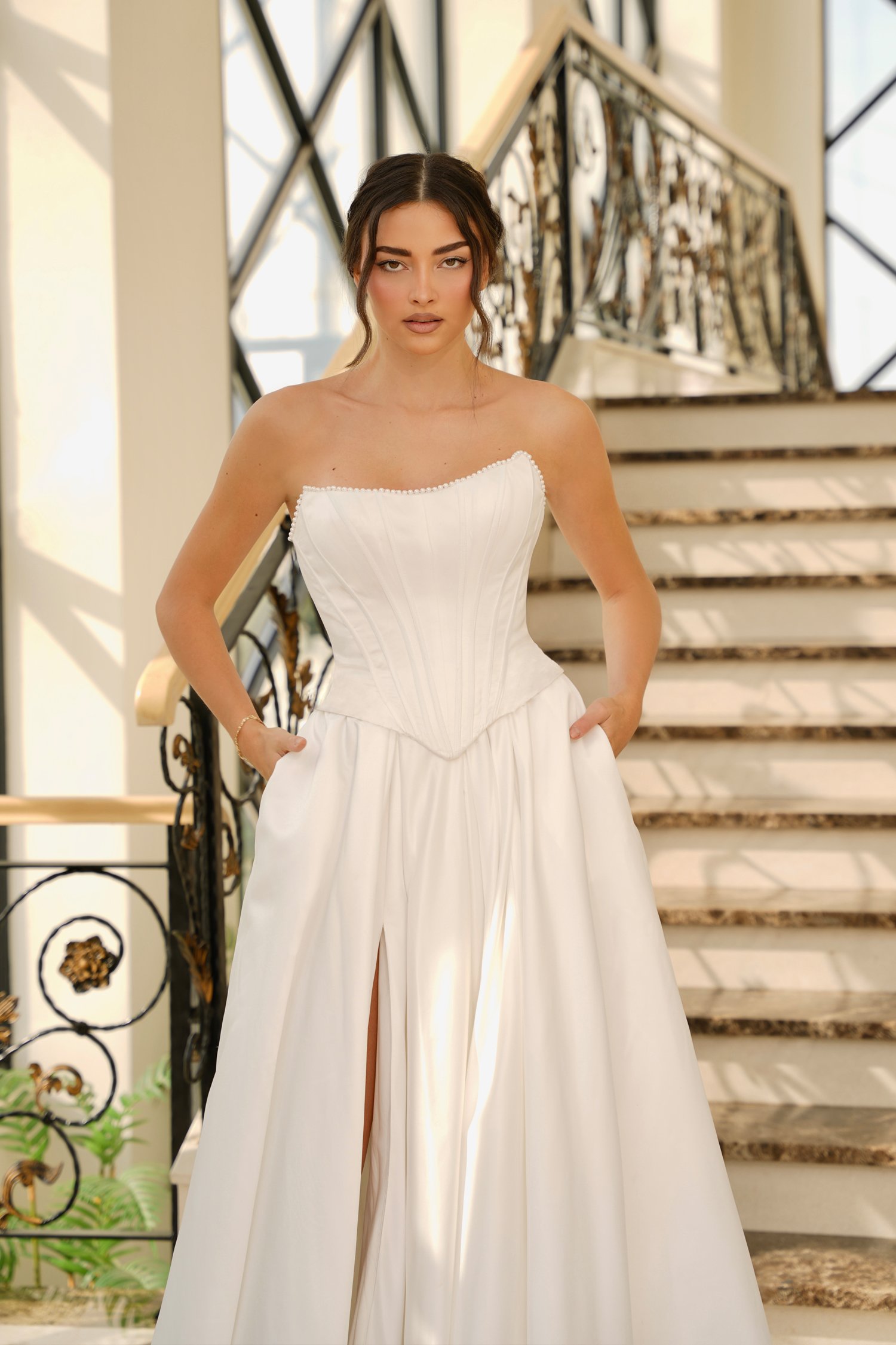 Delicate pearl detailing traces the neckline, adding a soft, romantic finish.