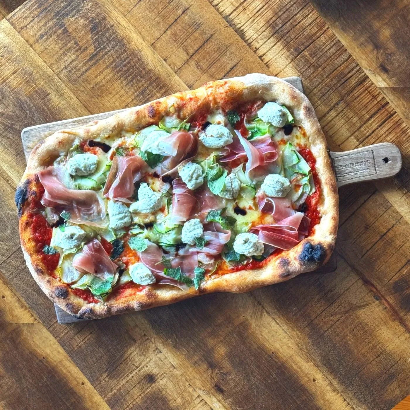 No.7 Pizza shown as a flat-lay on wooden table.