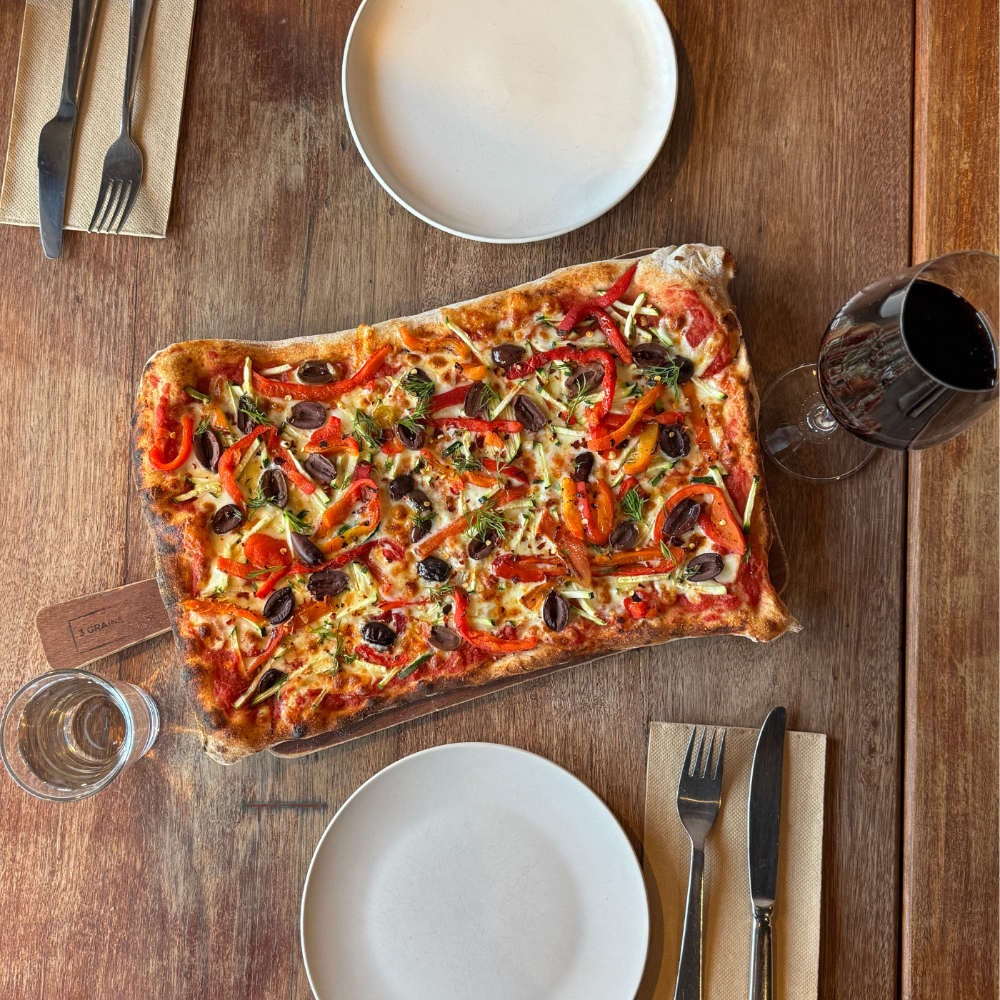 Maximus Pizza shown as a flat-lay on wooden table.