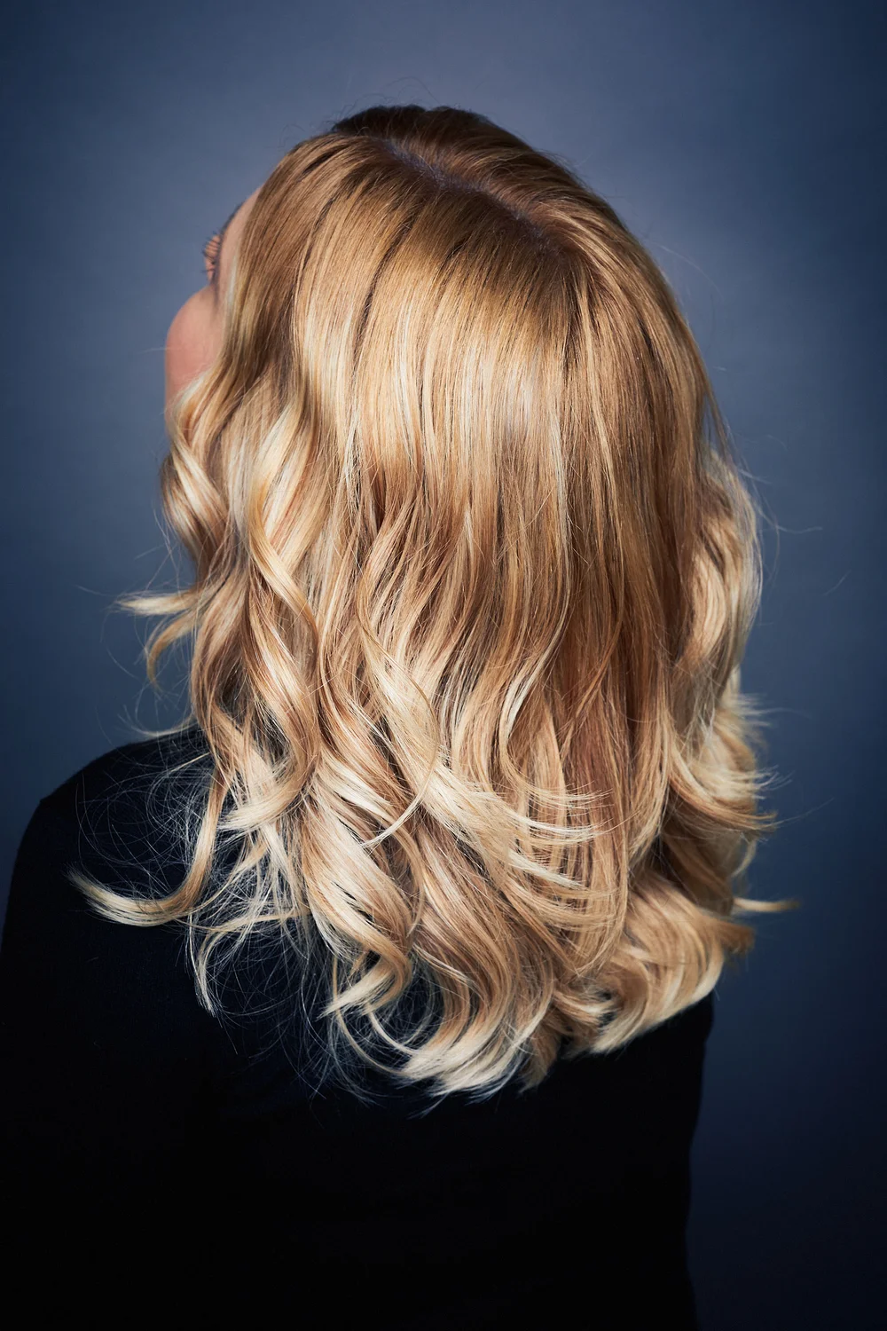 Blondes, gewelltes Haar mit feinen Farbnuancen – Rückansicht.