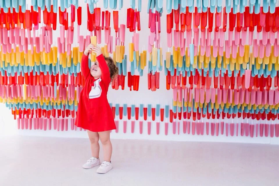 Taste melted ice cream in Food Figh t. Ummm. I’ll tast ice cream in any form thank you very much! The kiddies will LOVE the Sand Castle room. They (and you!!!) can play in pink sand to create their own sculpture, evocative of visits to the beach. I foresee lots of green gingham dresses to go all Lily Pulitzer in this room! Sweet Sculpture Studio is an opportunity to build your own masterpiece with colorful blocks. Kinda like Legos but better and in an ice cream museum! Hello! Pop some local goodies in your mouth at Pop , Also, strike a pose in front of a cascading wall of pink, red, blue and yellow popsicles. The popsicles are fake but you wish they were real! Start coordinating those outfits now! And of course, there’s the Sprinkle Pool . They even have lockers where to store your stuff, gold showerheads, and naturally, a pool full of sprinkles. Not real sprinkles you can devour, but plastic sprinkles. No Diving In the Pool, please! Have fun! AZUCAR!