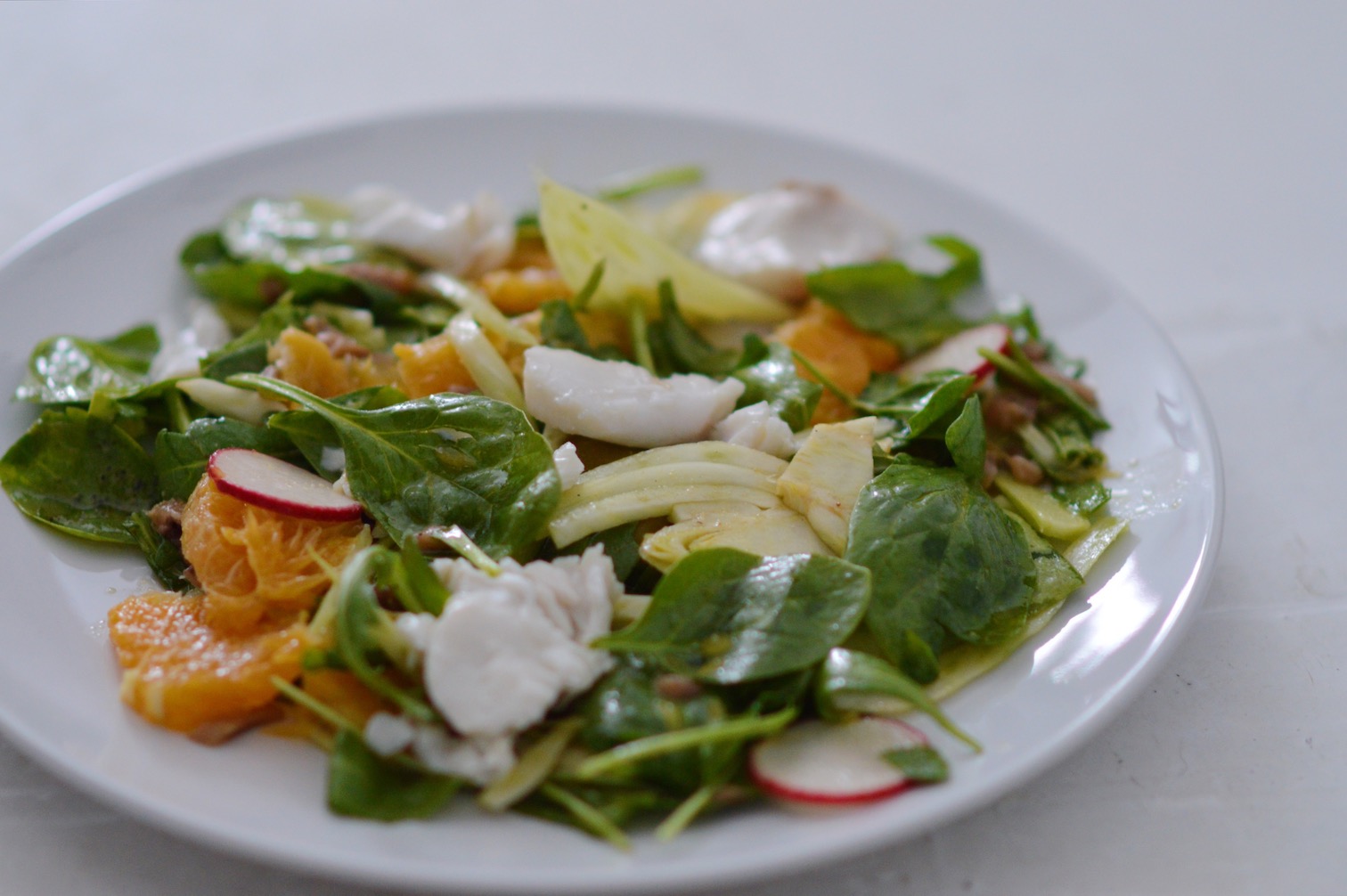 Ensalada de rúcula y naranja con migas de merluza