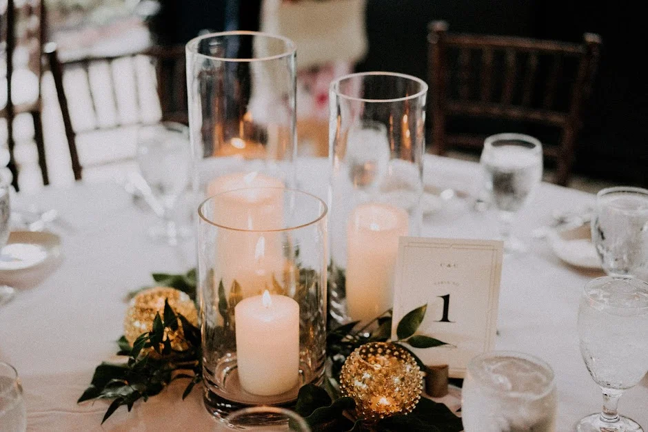 All of the candle centerpieces featured different hurricane glasses with gilded gold votive candle holders. 