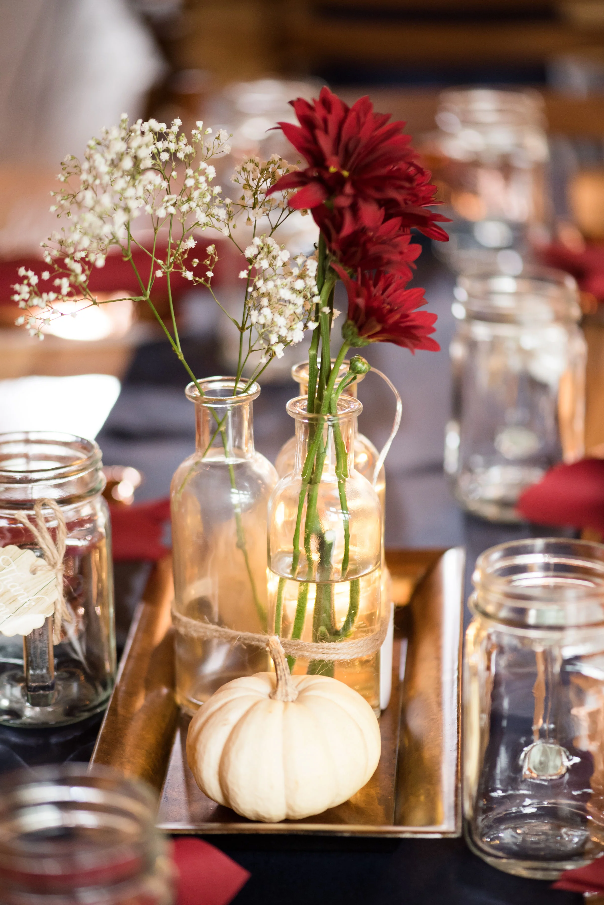Katie and Dan fall centerpieces were mixed bud vases and gords with mason jar favors.