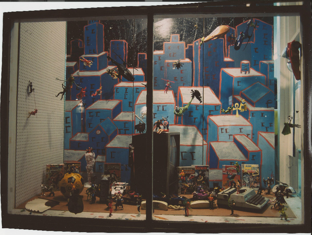  Action Figures. Photo by Dennis McGovern. Window by Brian Hibbs. All characters (c) their respective owners. Window took nearly 8 hours to construct, and within two nights someone broke the glass and stole (only) the Flash figure running up the left