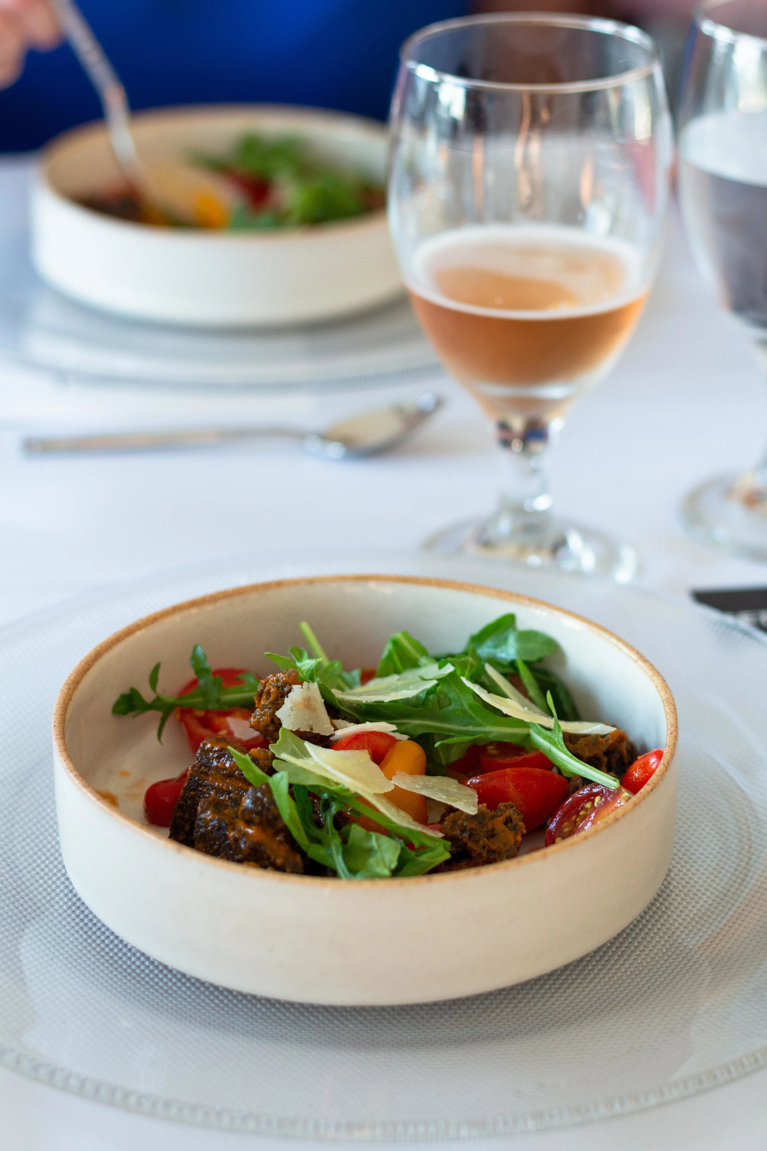 Tomato Salad made with squid ink sourdough, el trigal manchego, aged garlic chile honey. Paired with rosé beer.