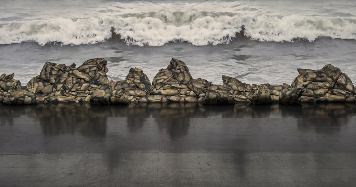 Shoreline, digital photographs printed on bags of recycled polyester, sand, cable ties, video projection, variable dimensions (photo: Ernest Mayer)