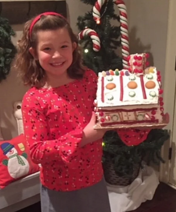My youngest daugther and her completed gingerbread house.