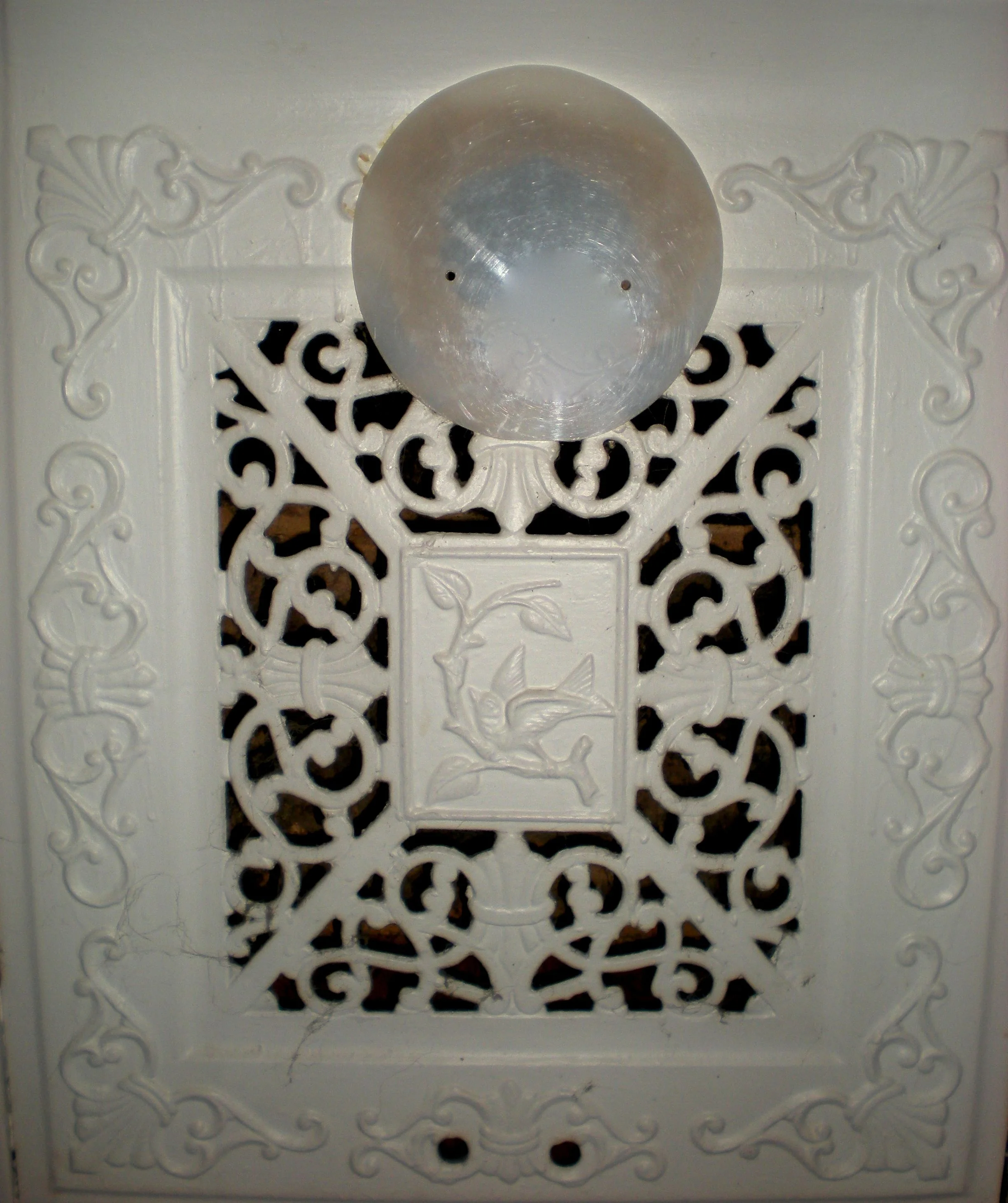 This decorative disk was commissioned for the grill over this fireplace. The copper piece replaced the plexiglass disk pictured here.