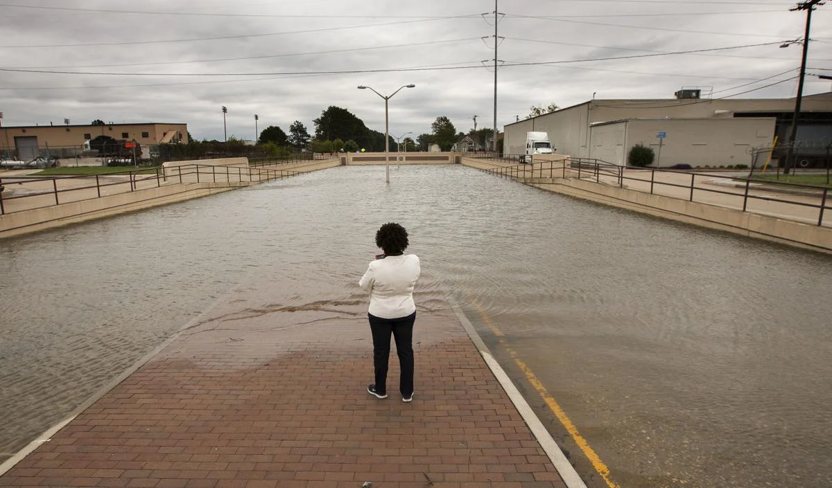 “A passerby stands in the median and looks over the flooded underpass on Virginia Beach Blvd. near Tidewater Drive in Norfolk on Sunday, Oct. 9, 2016.” (Bill Tiernan | The Virginian-Pilot)