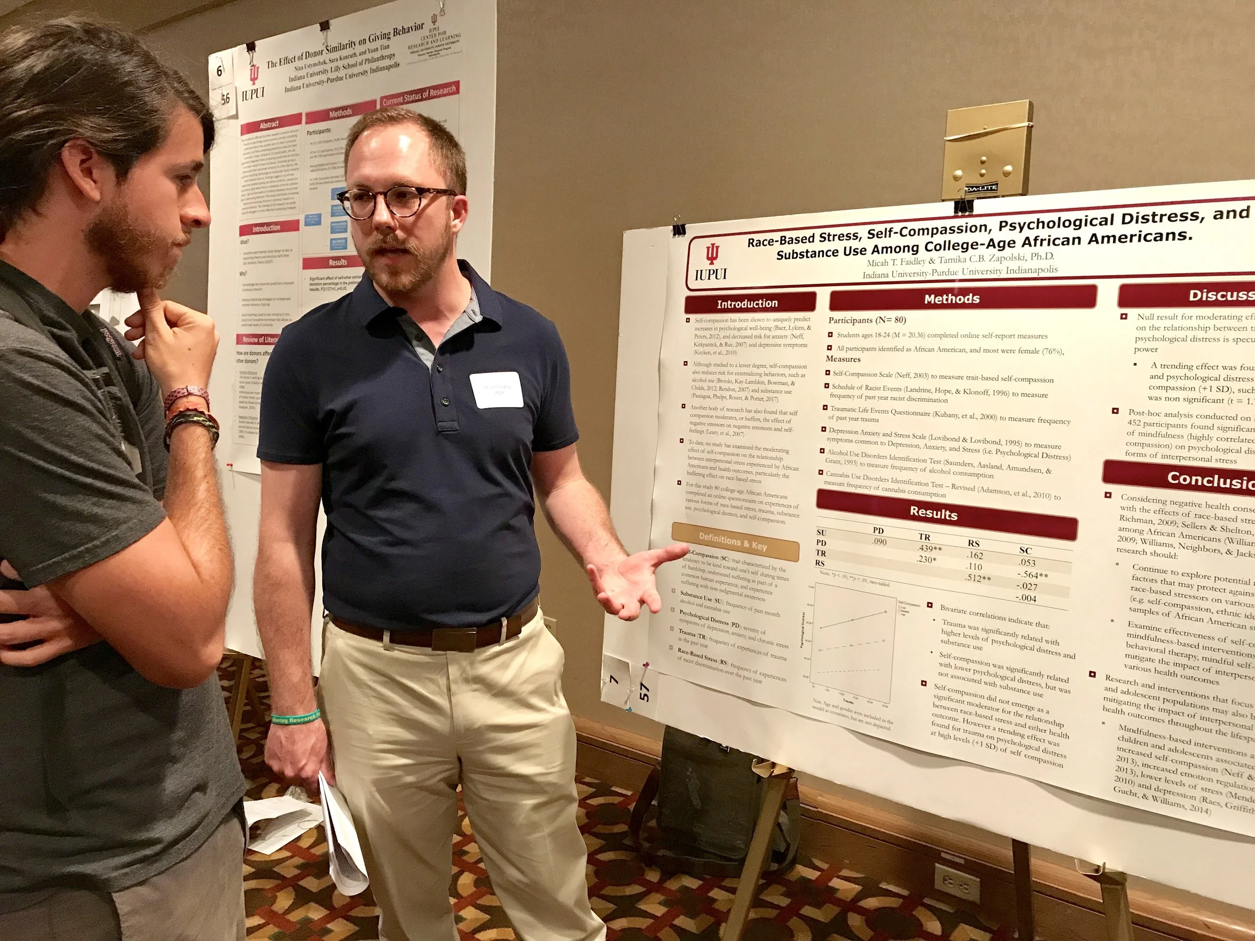 Micah presenting his poster to an attendee.