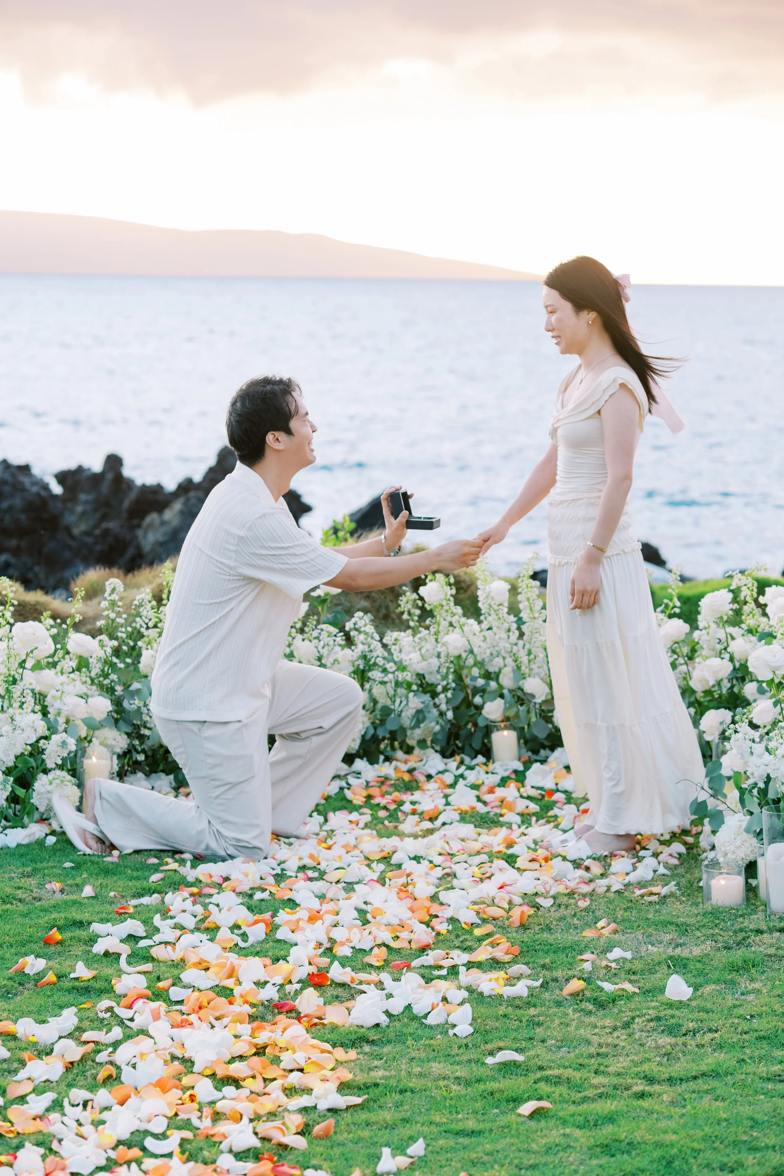 A couple at sunset having an intimate private proposal at the White Orchid Beach House in Makena.