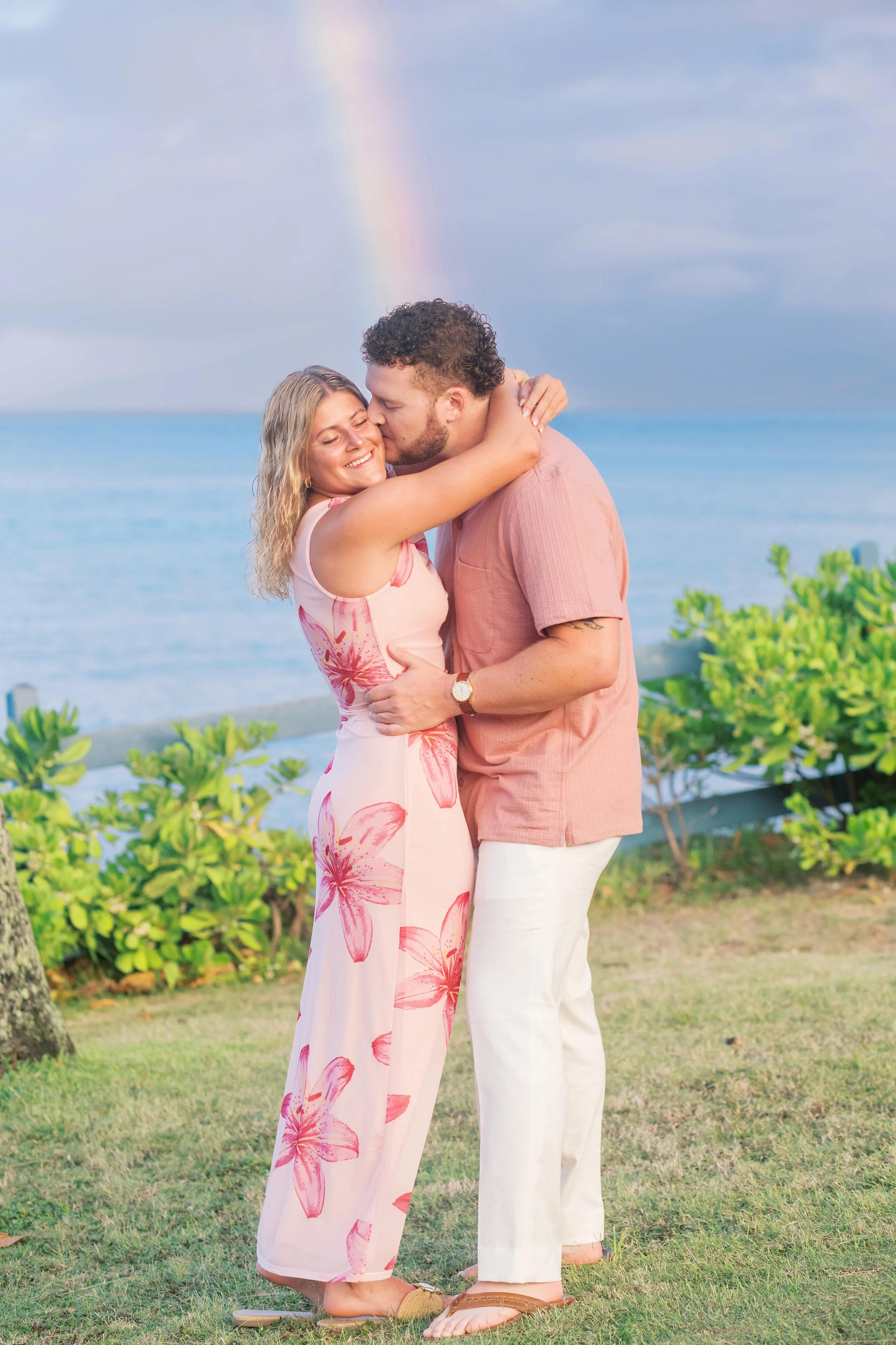 A surprise engagement photoshoot in Maui Hawaii at Kapalua Bay with a rainbow in the background.