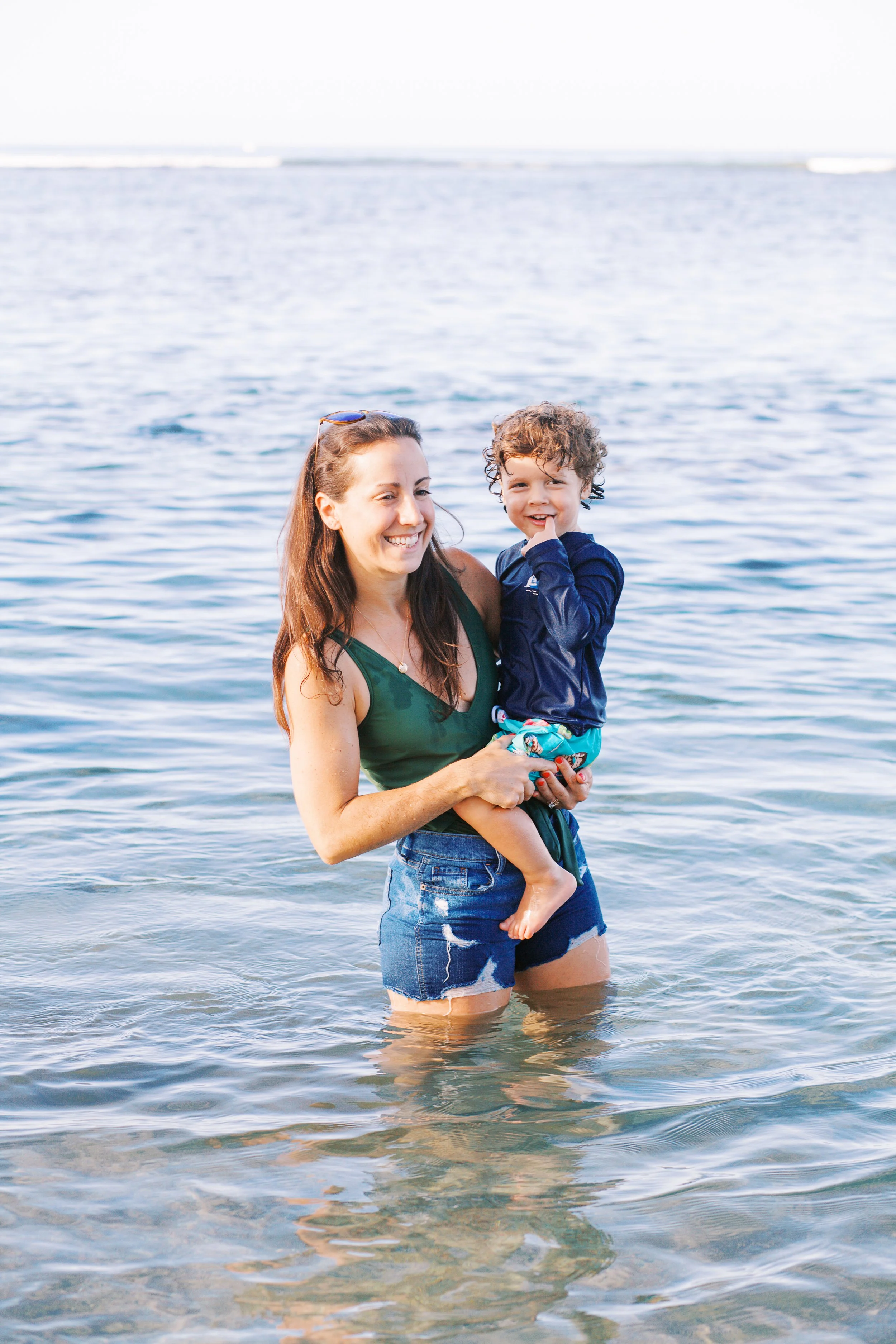 A mother holding her son in the ocean during a family photoshoot in Maui Hawaii.