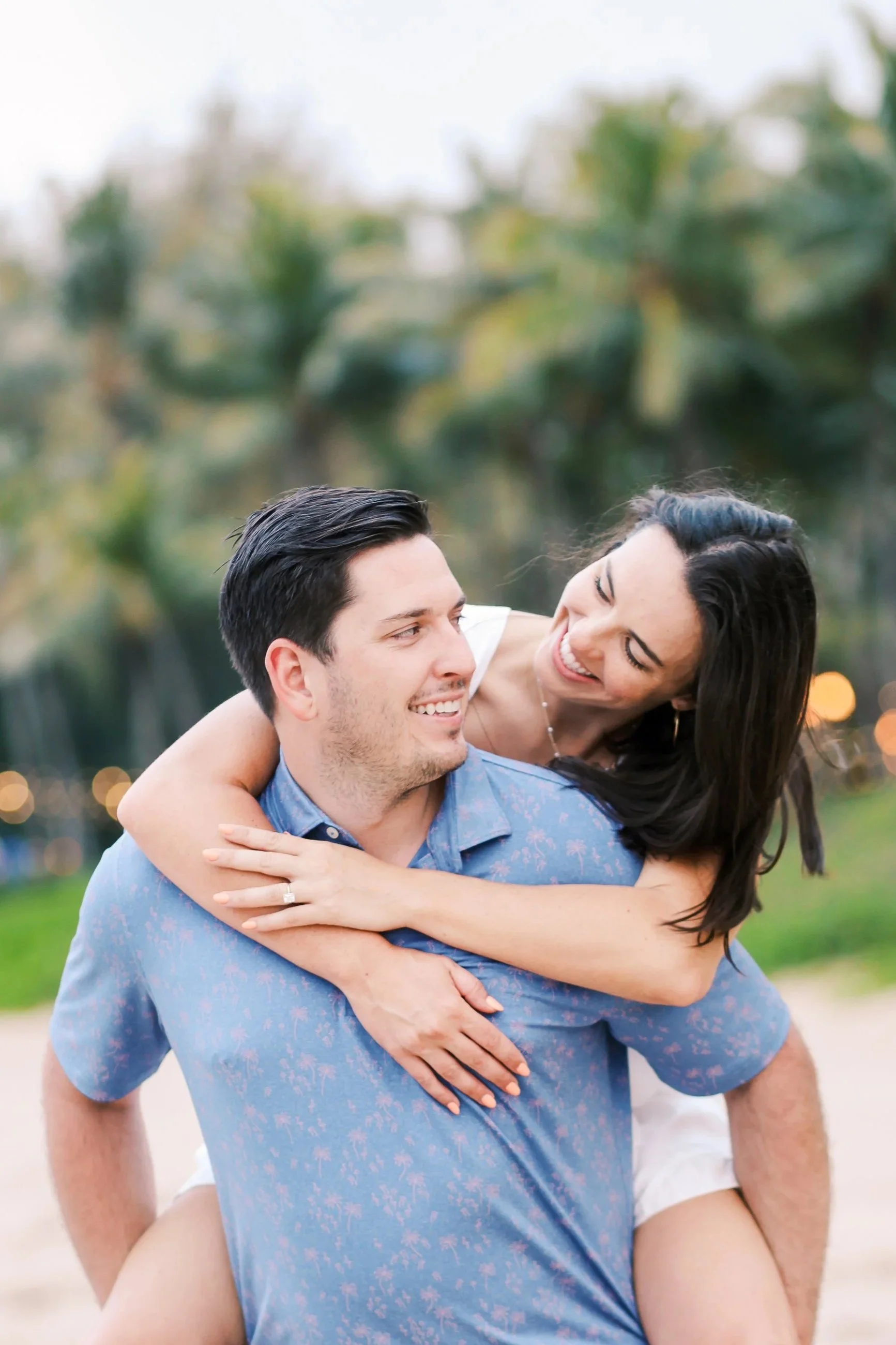 An engagement photoshoot at the Ritz Carlton on Maui in Kapalua at sunset with a couple laughing together.