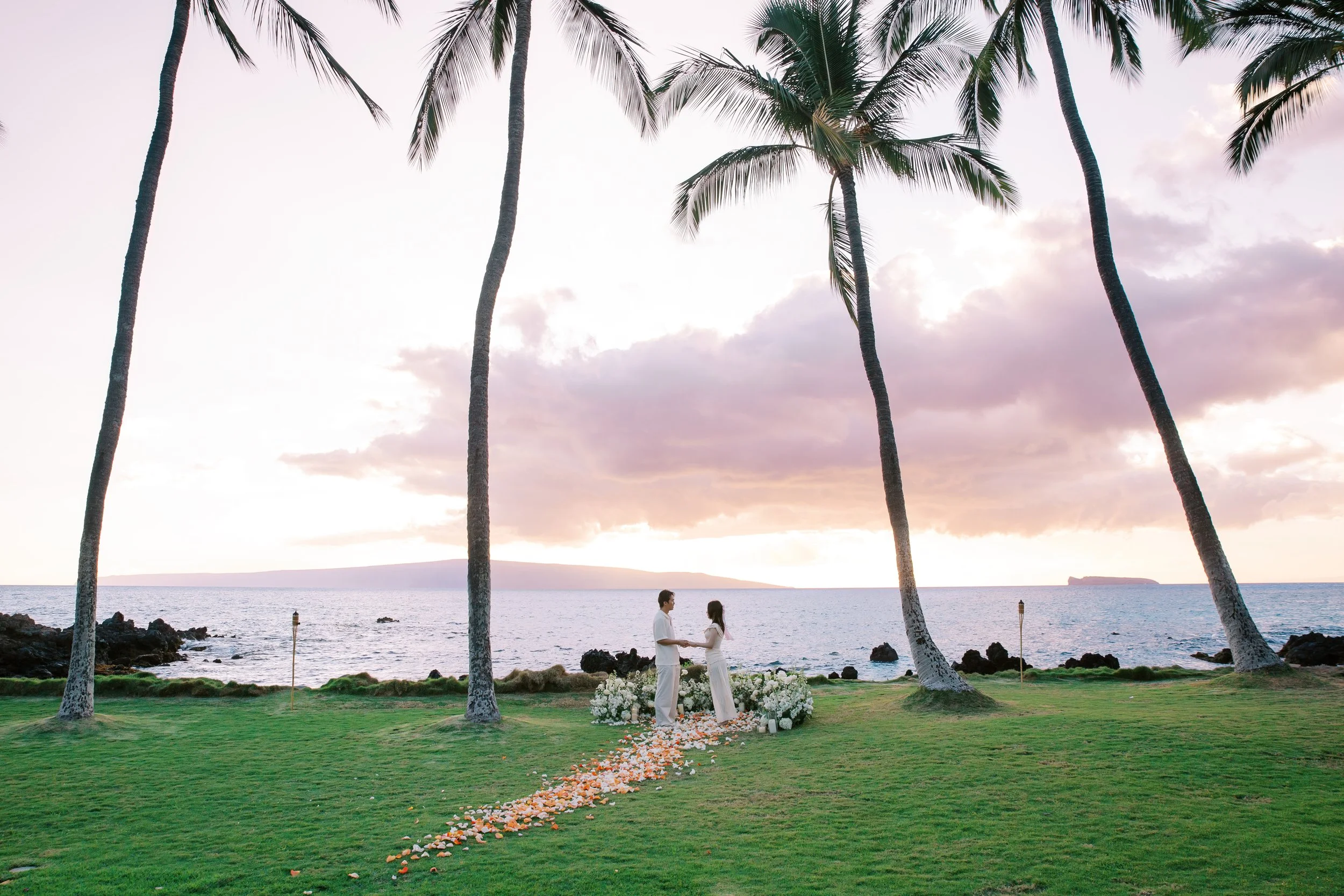 A vibrant South Maui sunset for a private proposal with a floral setup at the White Orchid Beach House.
