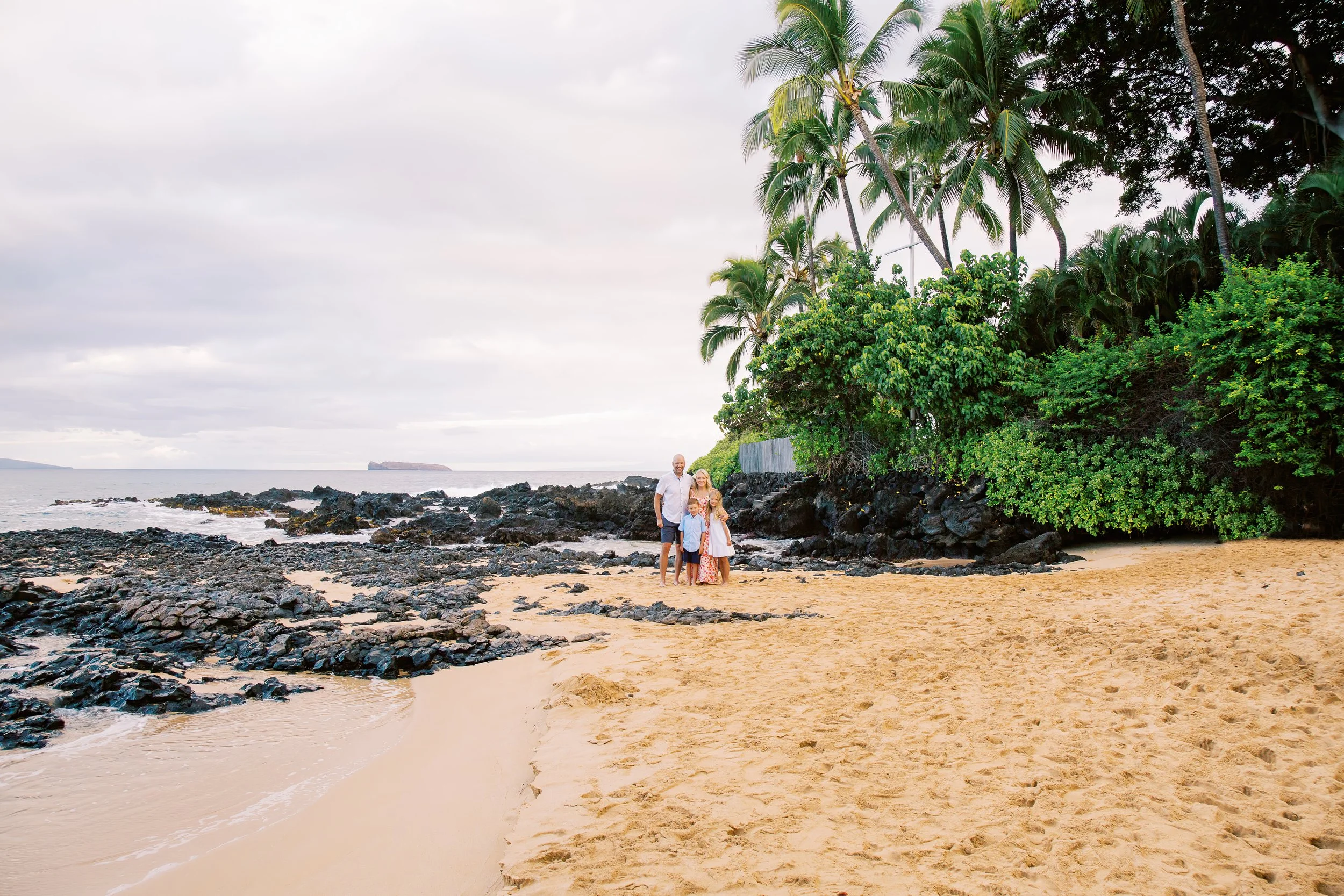 Family standing on the beach at Makena Cove