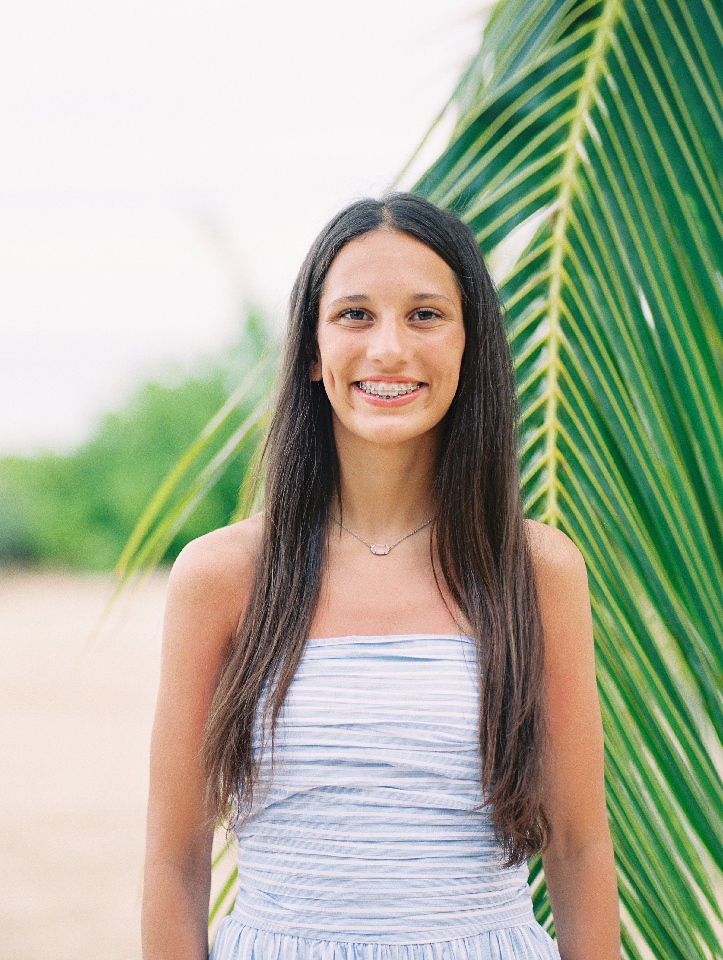 Waikiki senior photos with a palm tree in the background captured on film.