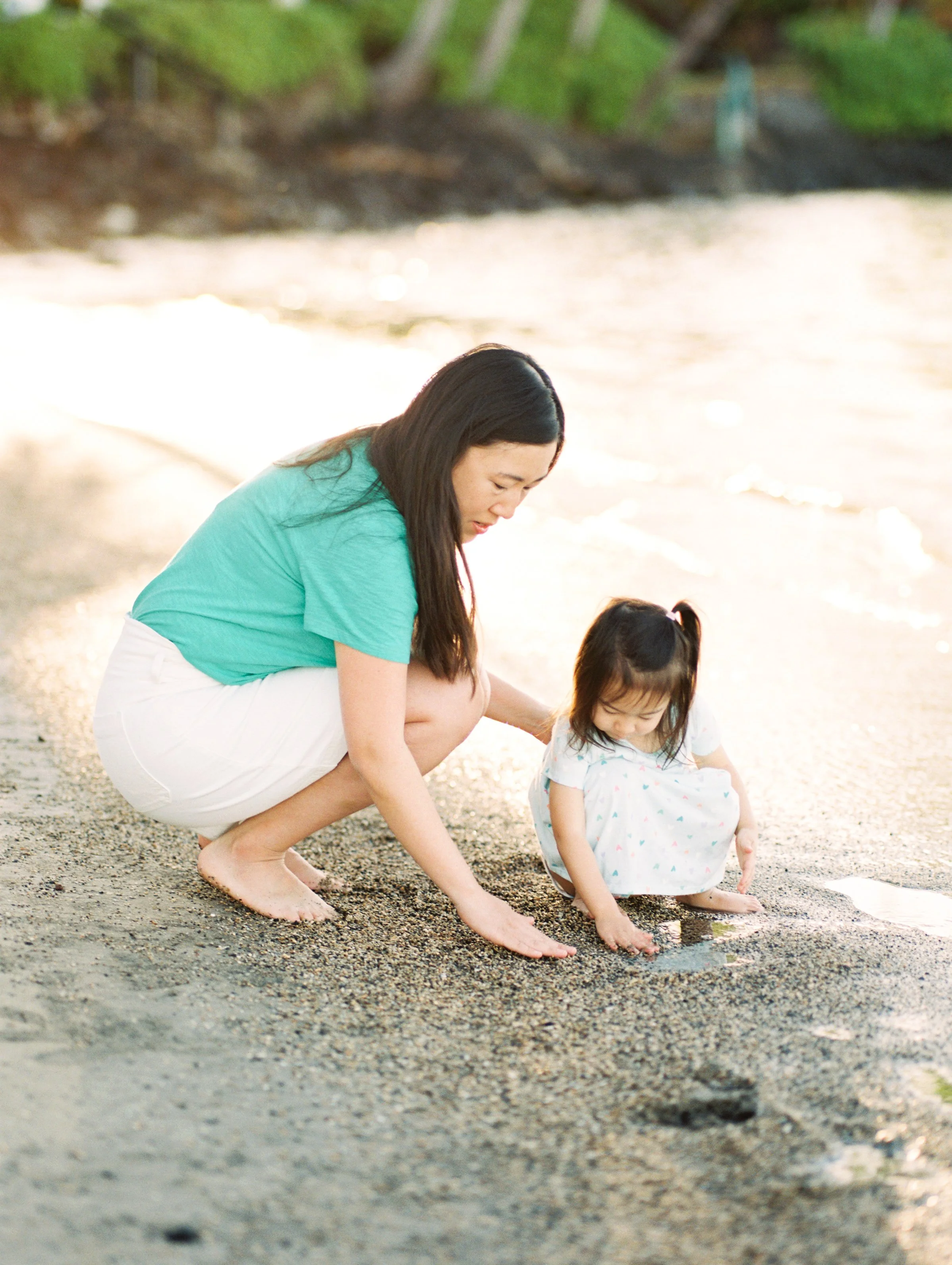 A mother and daughter playing on the beach in Lahaina Maui captured using film photography.