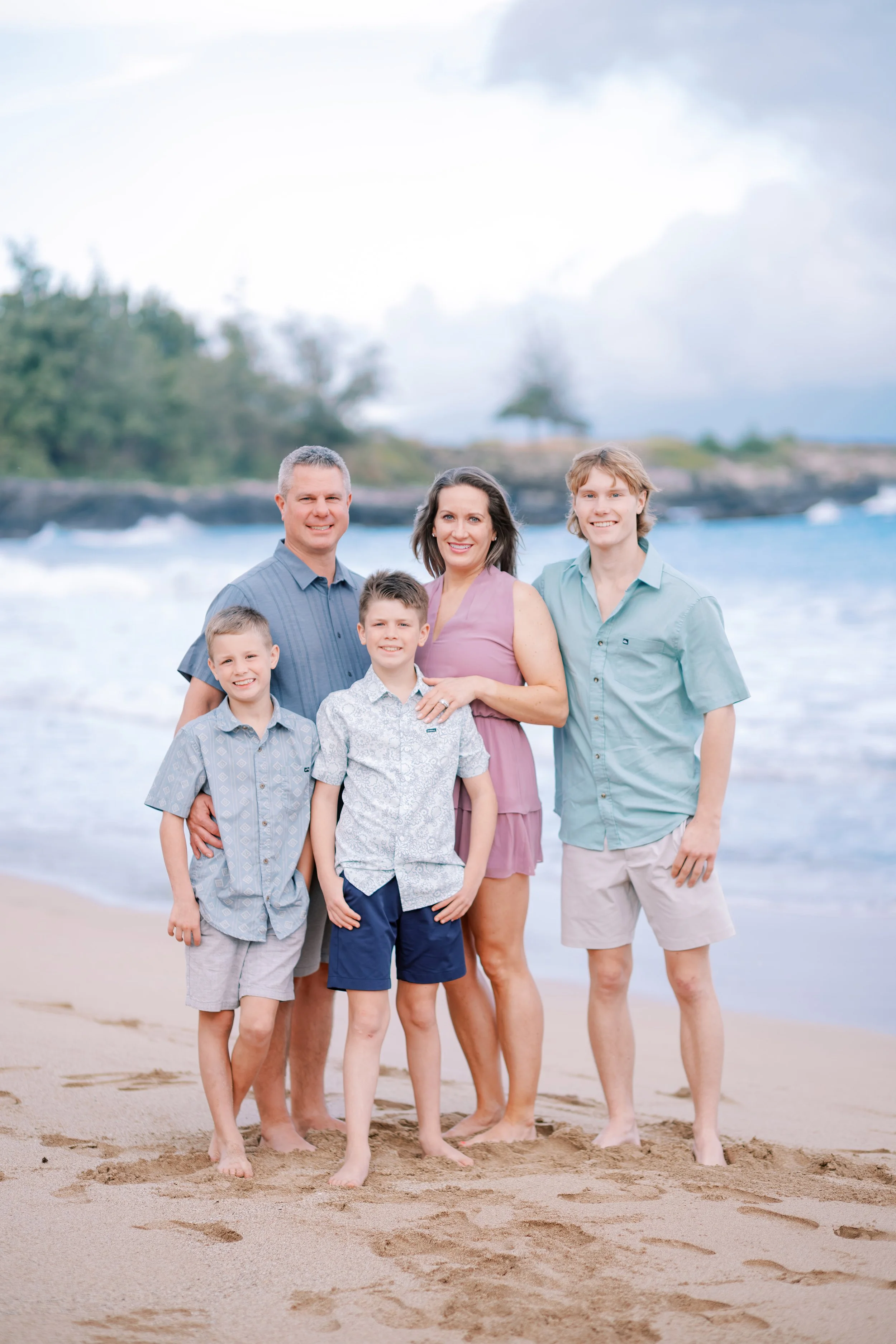 A family beach photoshoot taking place in Kapalua at the Ritz Carlton on Maui during a rainy morning.