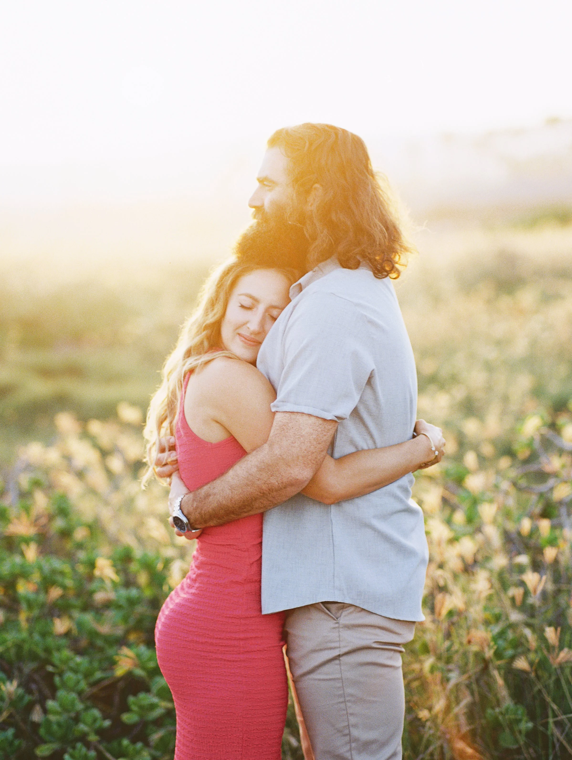 A couple drenched in the morning light above Ironwoods Beach in Maui captured on film photography.
