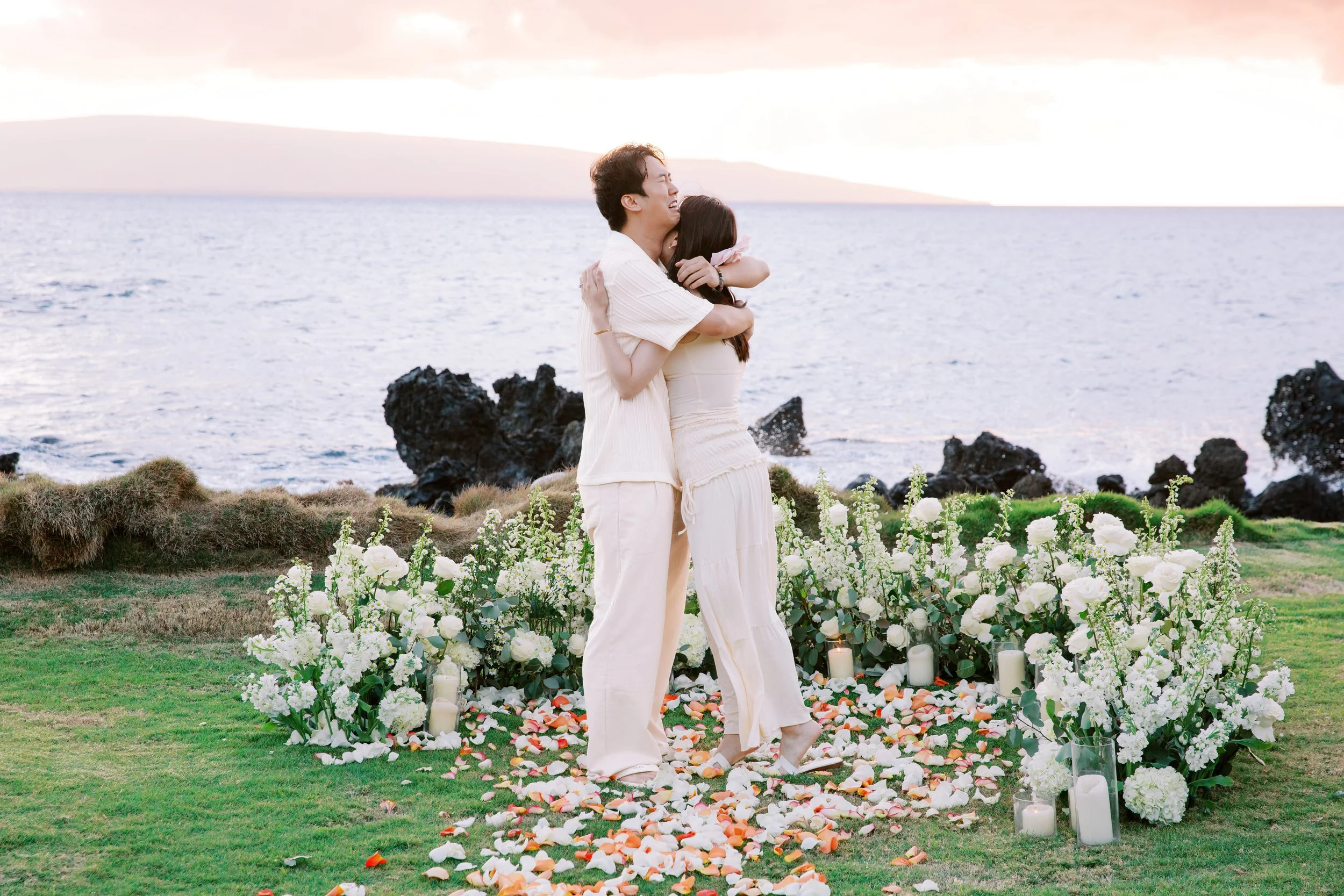 An intimate moment shared between a couple after a private sunset proposal on Maui in Makena.