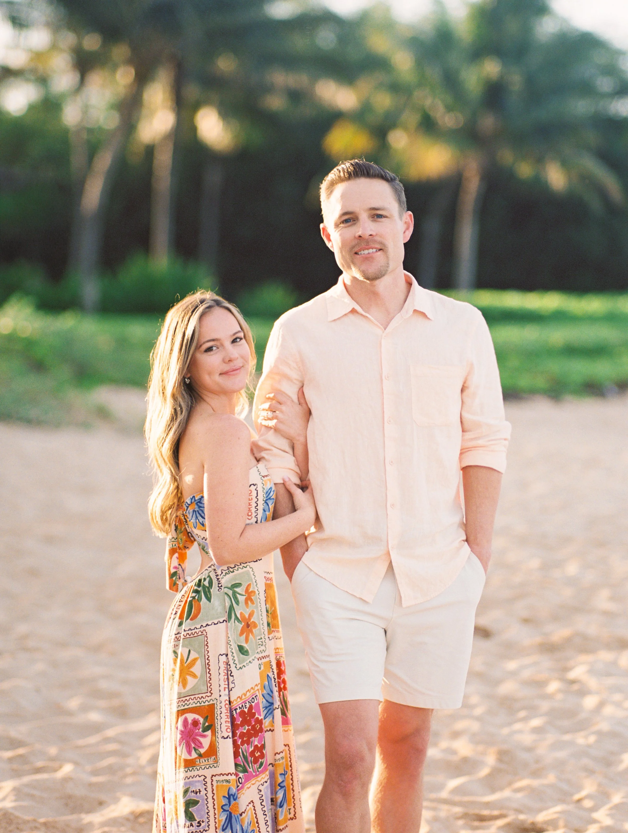 A couple standing on a beach in Wailea for an engagement photoshoot in the early morning.