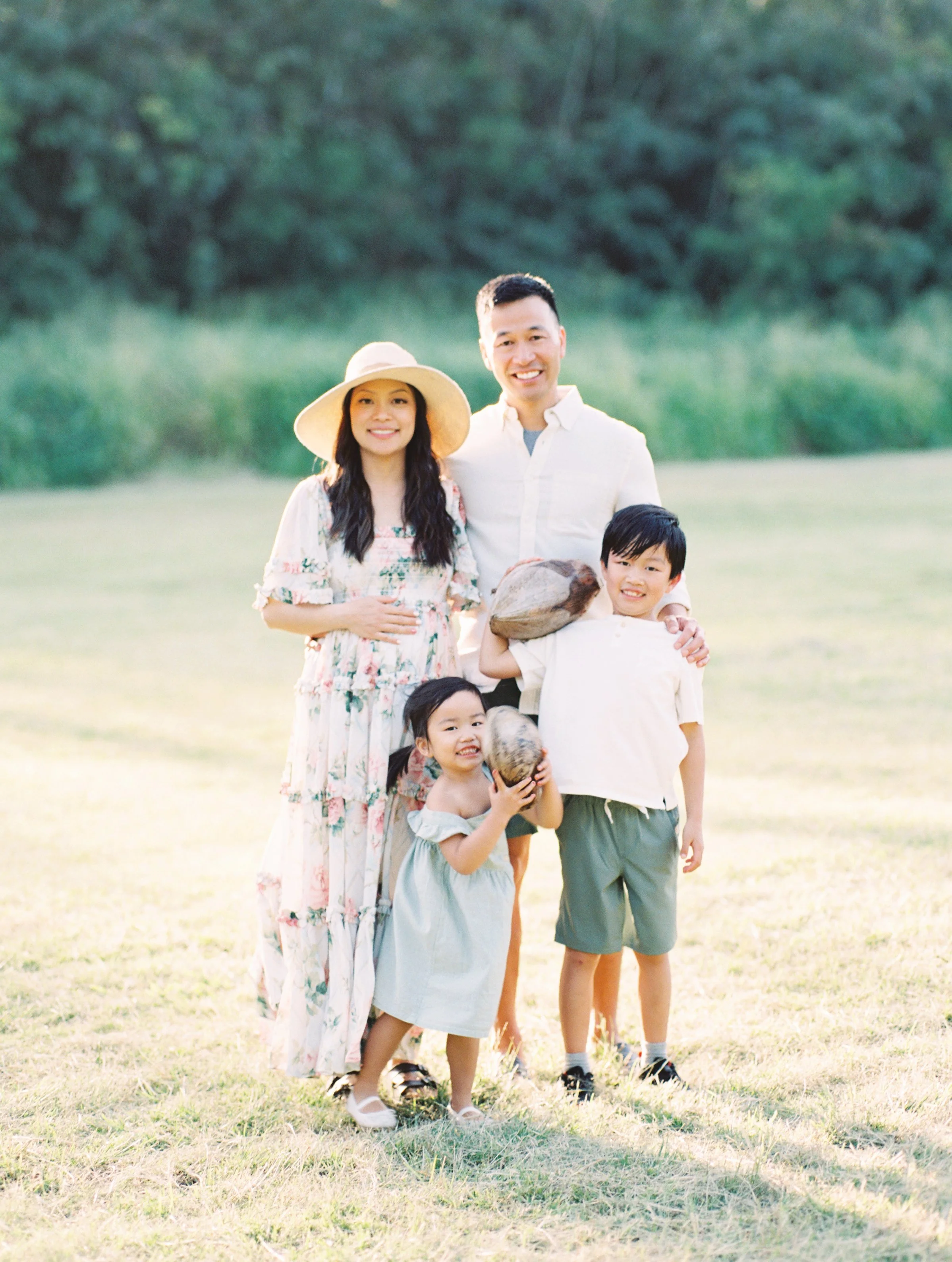 maui maternity family photos under palm trees in Kapalua