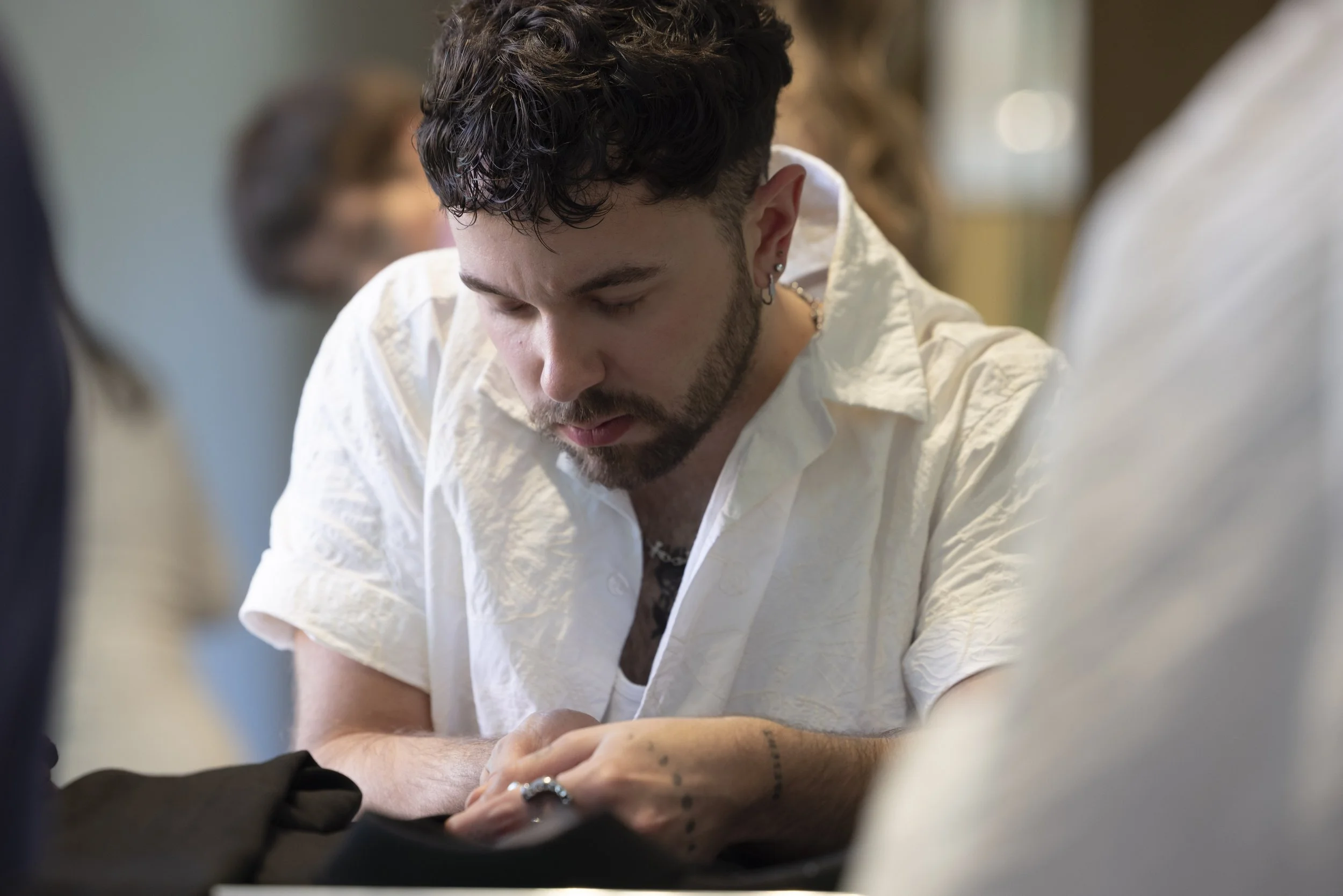 Young male participant sewing and upcycling clothing during a textile workshop at The Whitworth, Manchester, hands-on creative fashion and sustainability practice