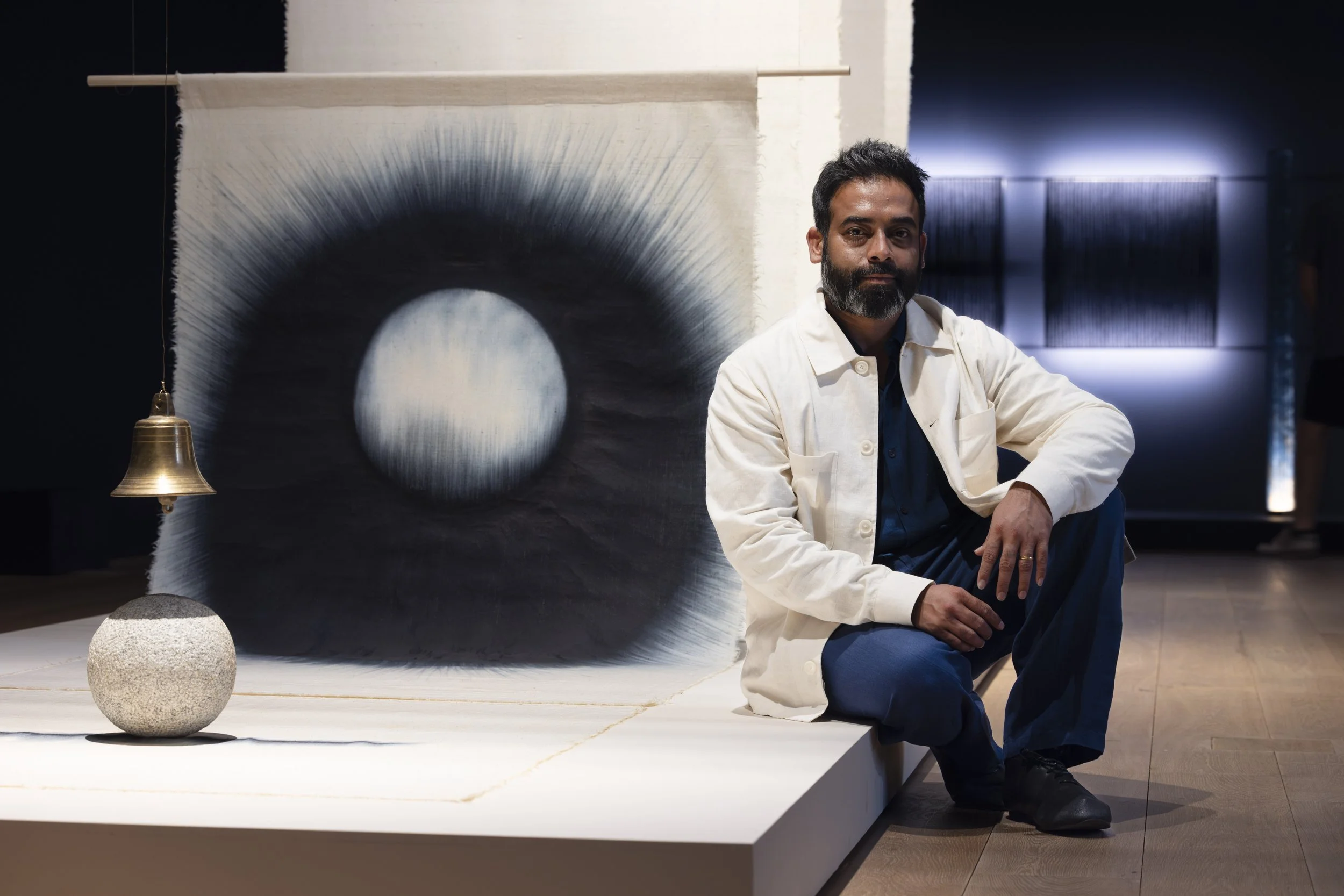 Artist Kaimurai with indigo textile works, bronze bell and carved stone sphere at the Whitworth